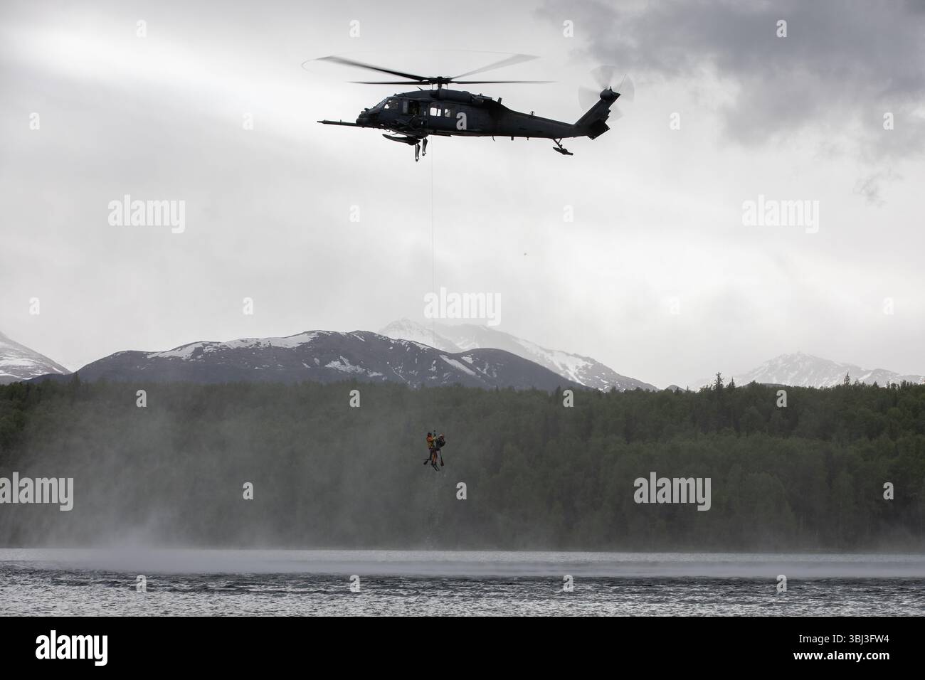 Alaska Air National Guard HH-60G Pave Hawk Aviators et Guardian Angels, affectés aux 210e et 212e escadrons de sauvetage, respectivement, mènent une formation en hélicoptère lors d'une démonstration de compétences à Otter Lake sur la base interarmées Elmendorf-Richardson, Alaska, le 30 mai 2025. L'héliocasting consiste à insérer dans l'eau du personnel de secours d'un hélicoptère stationnaire pour atteindre les survivants dans des environnements difficiles d'accès. (Photo de la Garde nationale de l'Alaska par Alejandro Peña) Banque D'Images