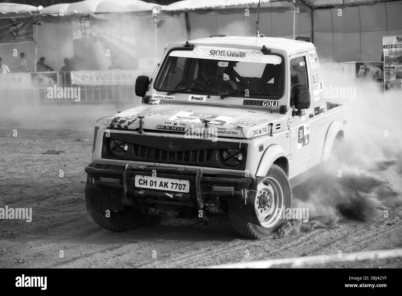 Une tzigane Maruti qui tire la poussière lors d'une manœuvre à grande vitesse lors d'un rallye moto en Inde. Banque D'Images