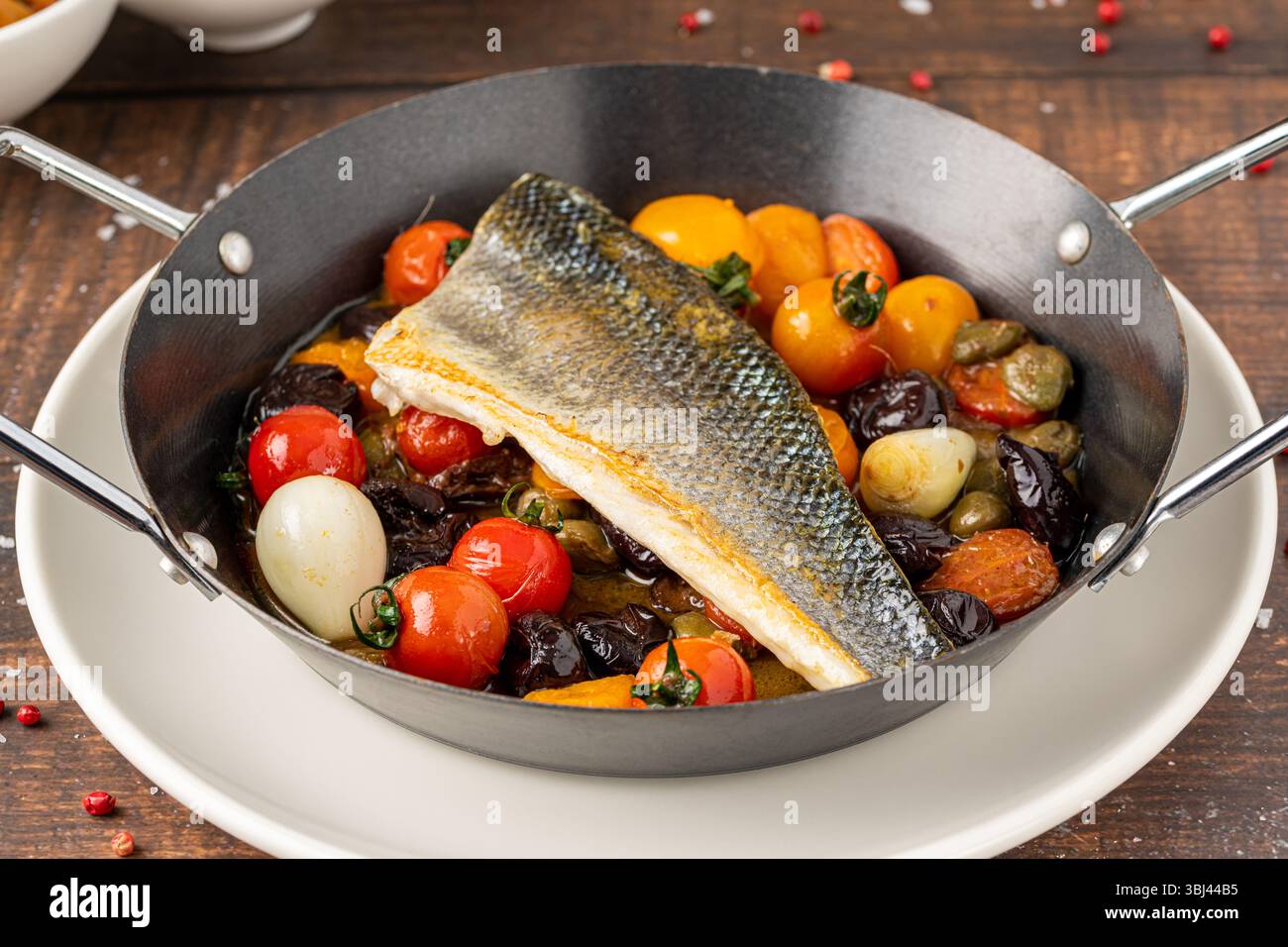 Filet de bar poêlé avec tomates cerises et légumes braisés Banque D'Images
