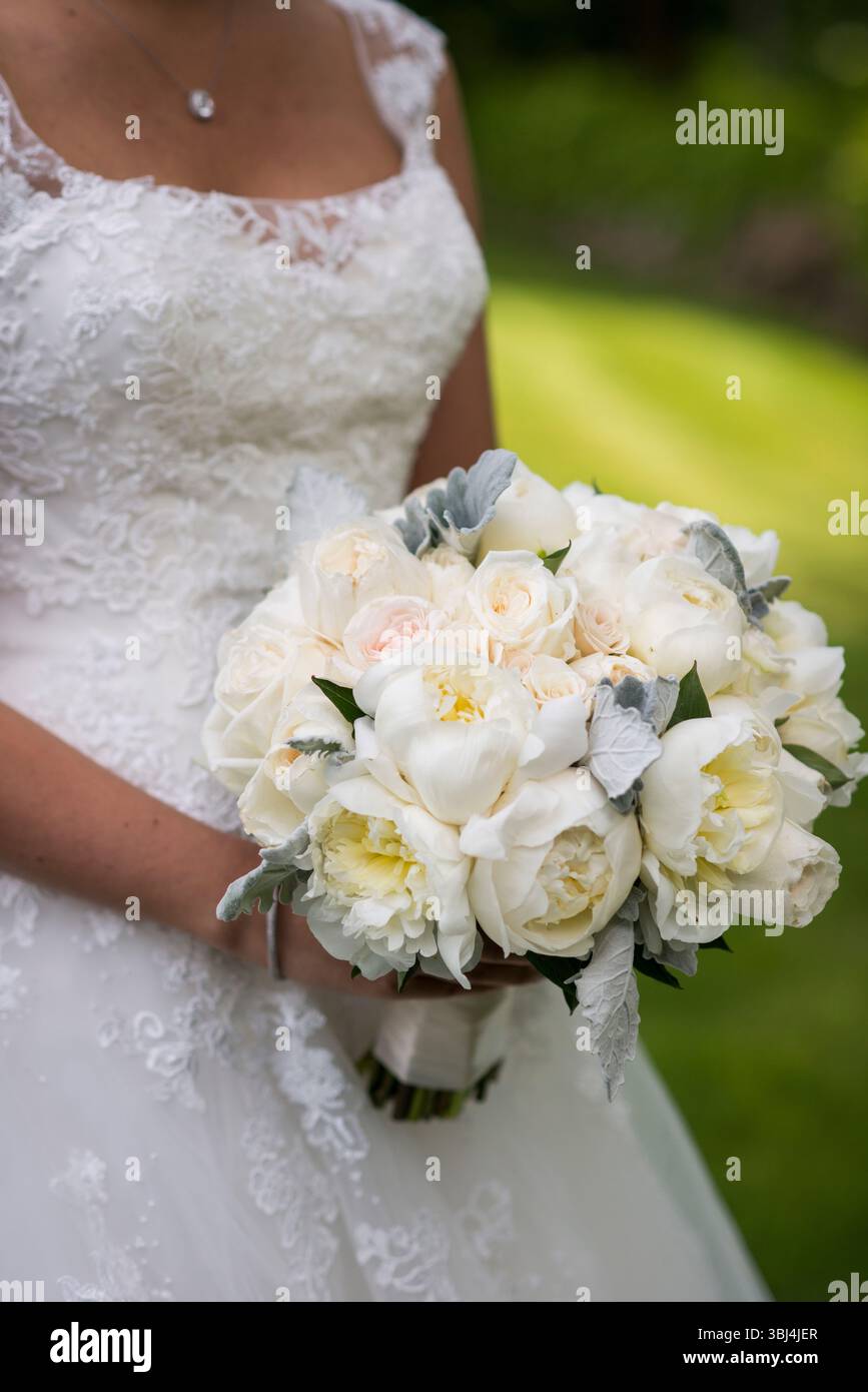 Mariée tenant le bouquet blanc classique dans la côte de Newport Banque D'Images