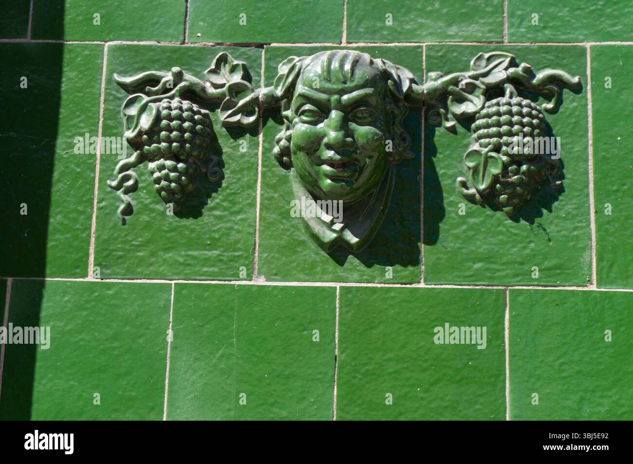 Élément décoratif (visage, grappes de raisins) sur le mur. Lębork, Pologne. Banque D'Images