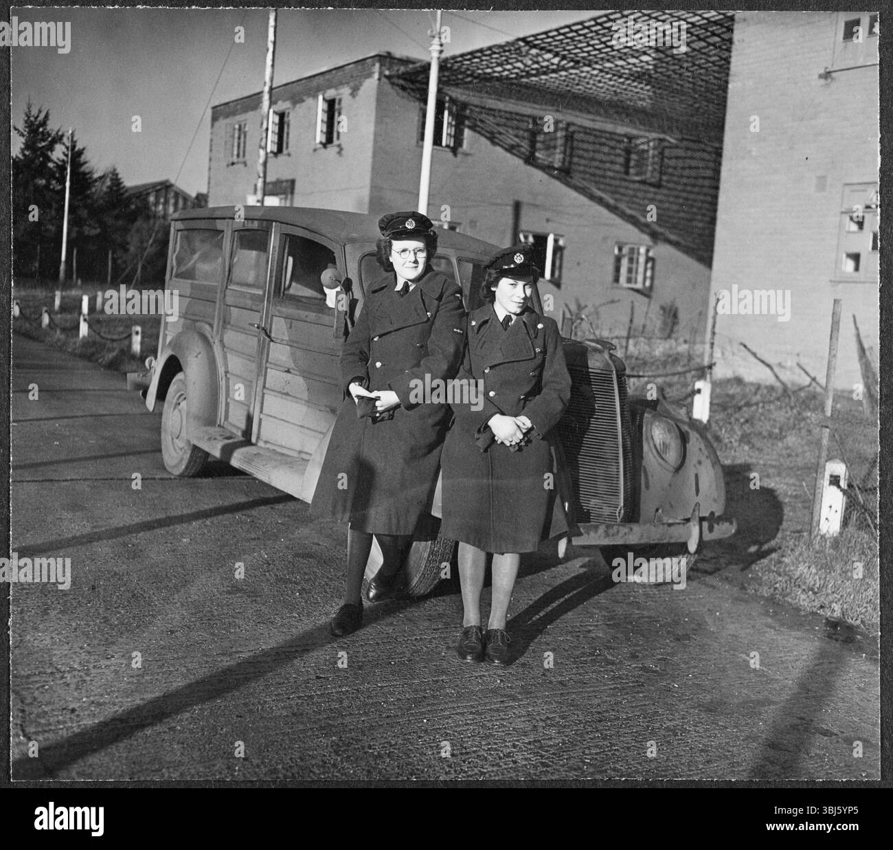 Les aviateurs de la WAAF Joan Curran et PAM Hicks en uniforme ont posé pour la caméra devant un camion militaire devant la RAF Iver Heath, Pinewood Studios, Buckinghamshire, 1943. Pinewood Studios - ou RAF Iver Heath - a été utilisé comme base pendant la seconde Guerre mondiale pour la Royal Air Force film production Unit, la Crown film Unit, et l'Army film and Photographic Unit. Les studios ont été utilisés pour produire à la fois des films prônant le rôle des forces armées dans la guerre, et des films documentaires, enregistrant les progrès de la guerre. Dorothy 'Knicky' Chapman a été affectée aux studios Pinewood pour servir en tant que WAAF w Banque D'Images
