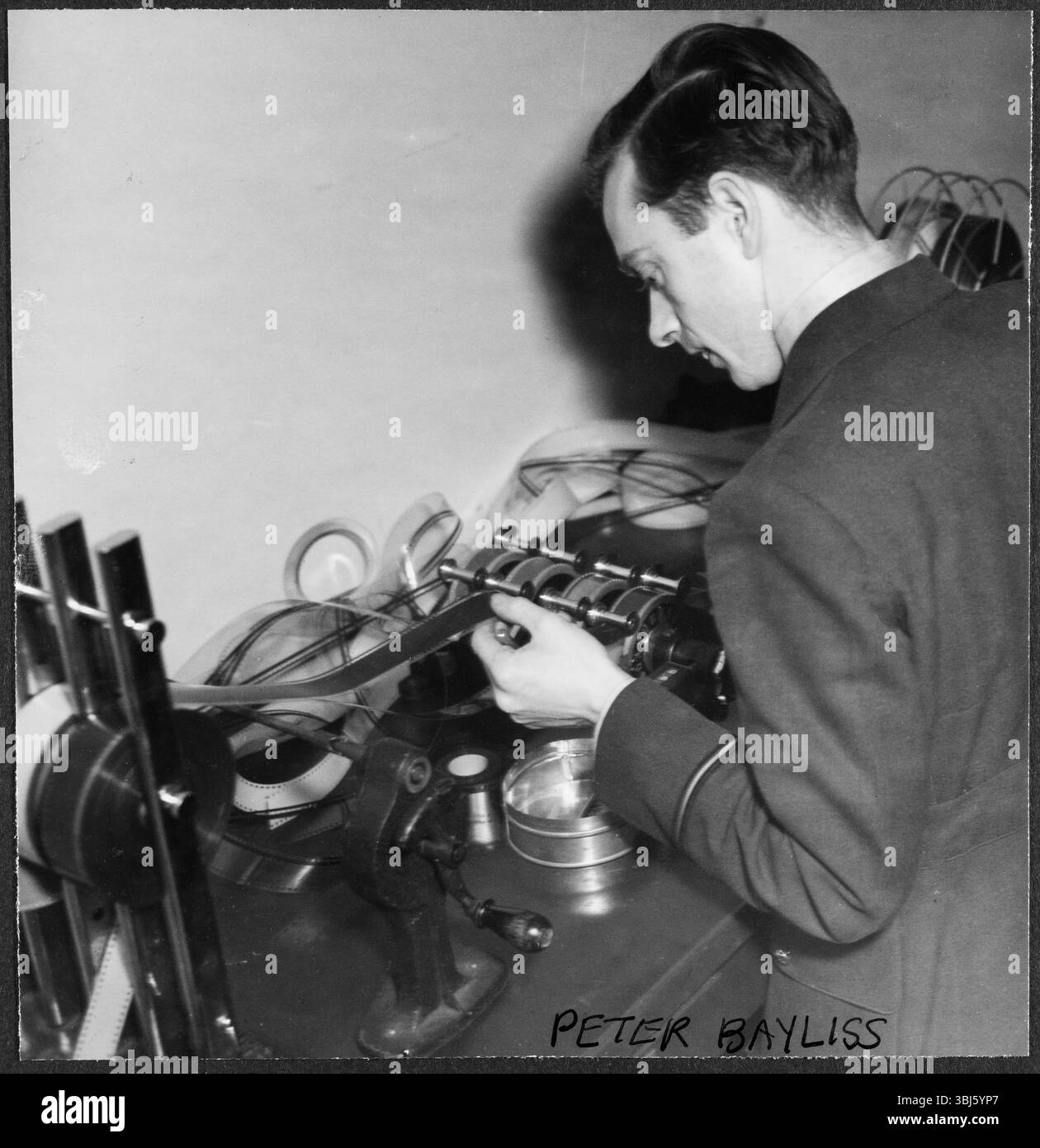 Peter Baylis, aviateur de la RAF, travaille sur un rouleau de film petit format dans la salle de découpe de la RAF Iver Heath, Pinewood Studios, Buckinghamshire, 1942-43. Peter Baylis a été monteur pour l'unité de production de films de la RAF pendant la seconde Guerre mondiale. Il apparaît également sur la liste de distribution de 'Journey Together', un film produit par l'unité en 1945 avec un jeune Richard Attenborough. Pinewood Studios - ou RAF Iver Heath - a été utilisé comme base pendant la seconde Guerre mondiale pour la Royal Air Force film production Unit, la Crown film Unit, et l'Army film and Photographic Unit. Les studios en étaient habitués Banque D'Images