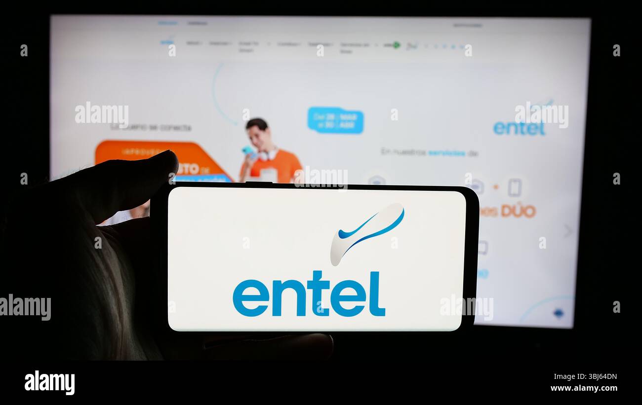 Stuttgart, Allemagne - 04-07-2025 : personne tenant un téléphone portable avec le logo de la société de télécommunications Entel S.A. sur l'écran en face de la page web Banque D'Images Stuttgart, Allemagne - 04-07-2025 : personne tenant un téléphone portable avec le logo de la société de télécommunications Entel S.A. sur l'écran en face de la page web Banque D'Images