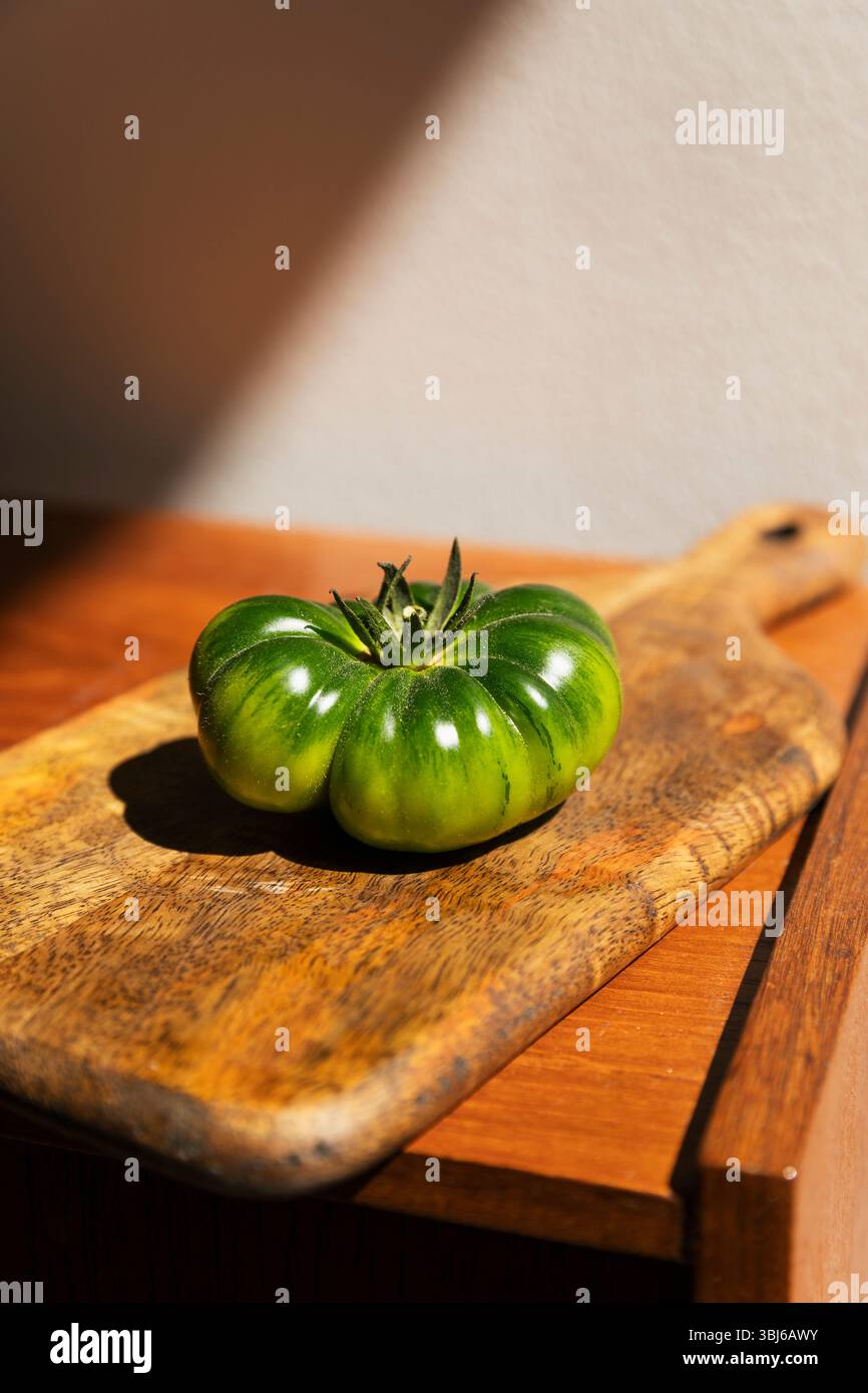 Tomate verte Heirloom sur planche de bois. Banque D'Images