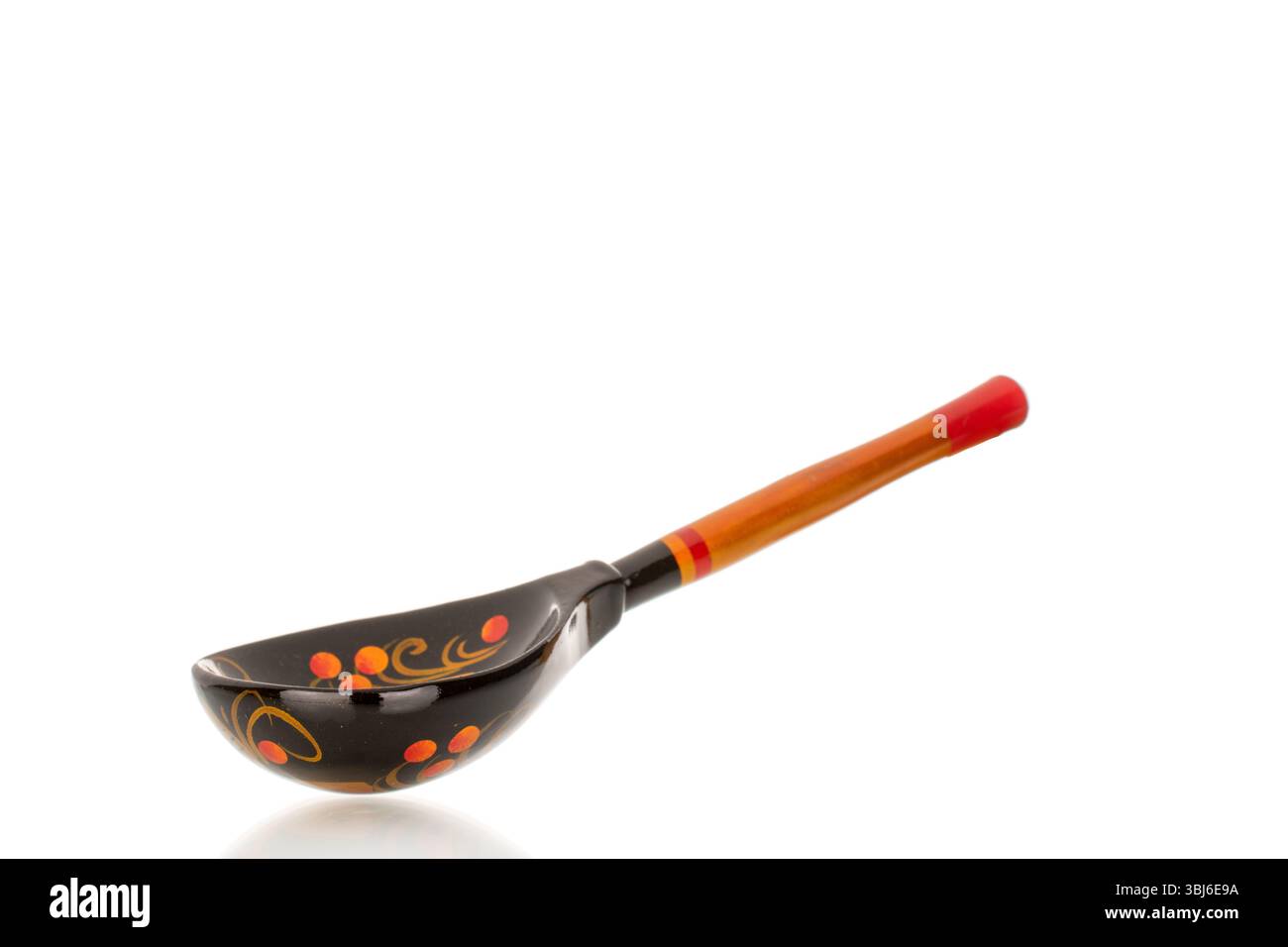 Une cuillère en bois peinte isolée sur fond blanc, gros plan. Banque D'Images