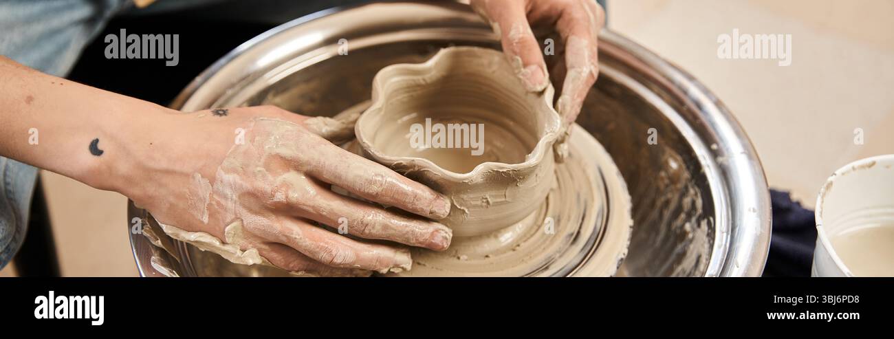 Un homme élégant fabrique avec passion une belle pièce de poterie tout en profitant de l'atmosphère créative. Banque D'Images