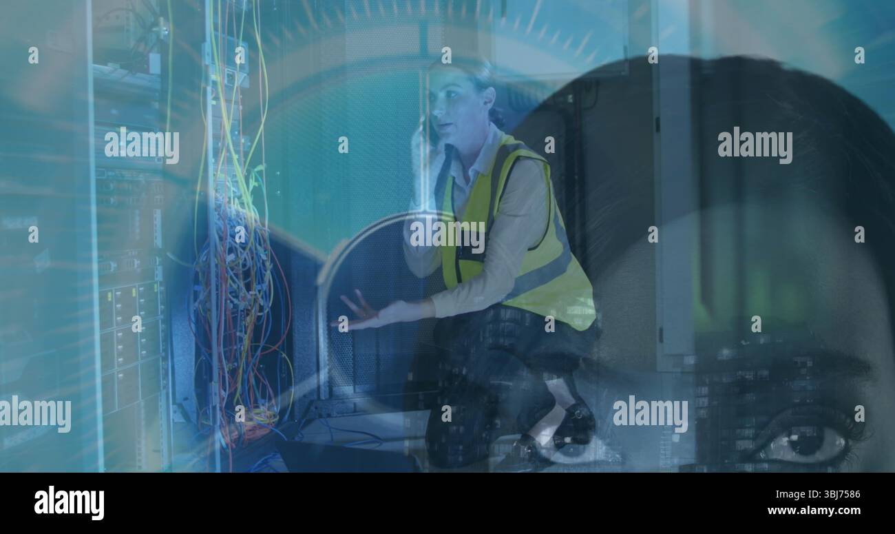 Agenouillement INFORMATICIEN tenant un smartphone, expliquant les câbles de rack de serveur dans le centre de données, avec recouvrement HUD Banque D'Images