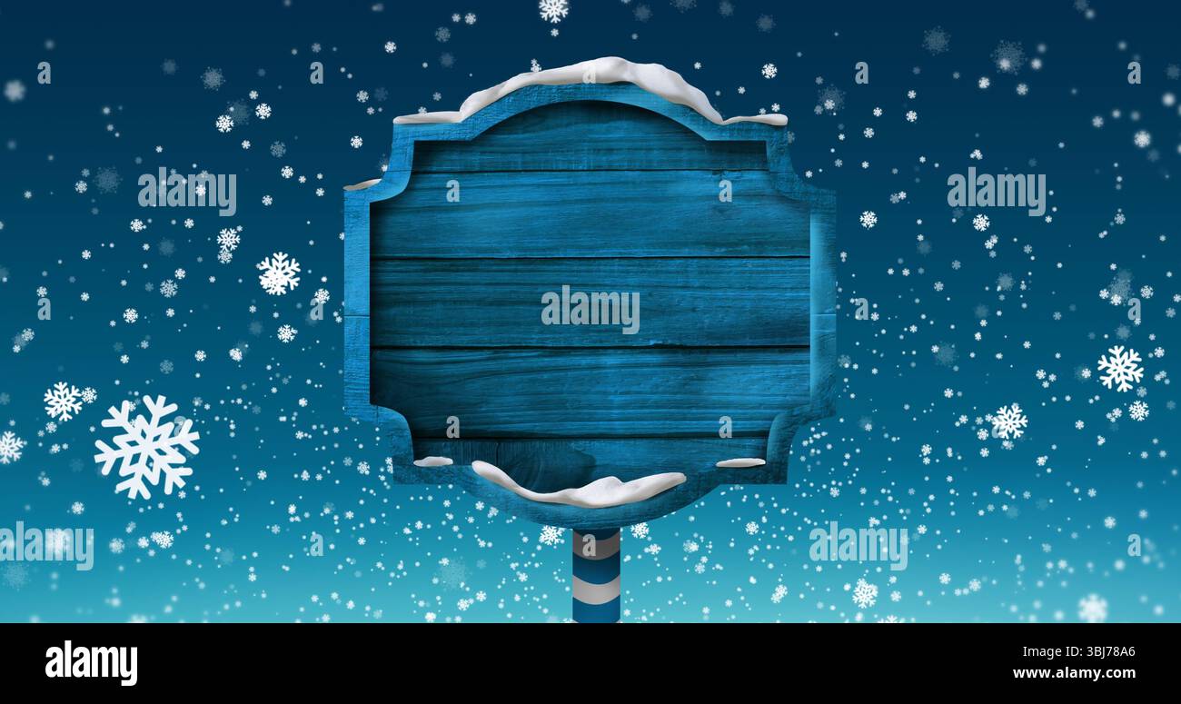 Affichage de panneau bleu en bois avec de la neige empilée sur un poteau rayé, flocons de neige flottants au ciel d'hiver Banque D'Images
