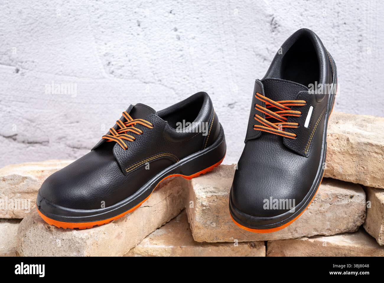 Paire de nouvelles chaussures de travail sur de vieilles briques. Mise au point sélective. Banque D'Images