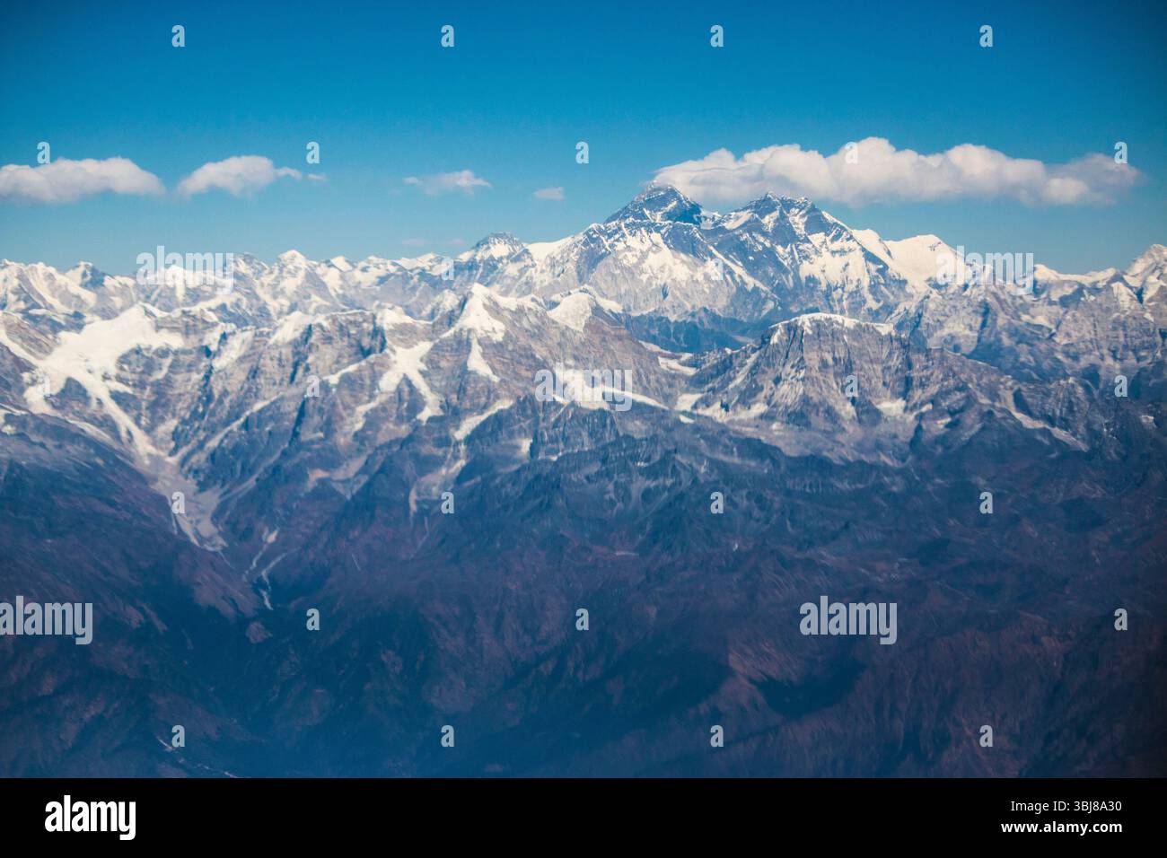 Vue aérienne de l'Himalaya depuis Katmandou : Mont Everest avec un panache sommital tours au-dessus des contreforts montants et des sommets enneigés du Népal. Banque D'Images
