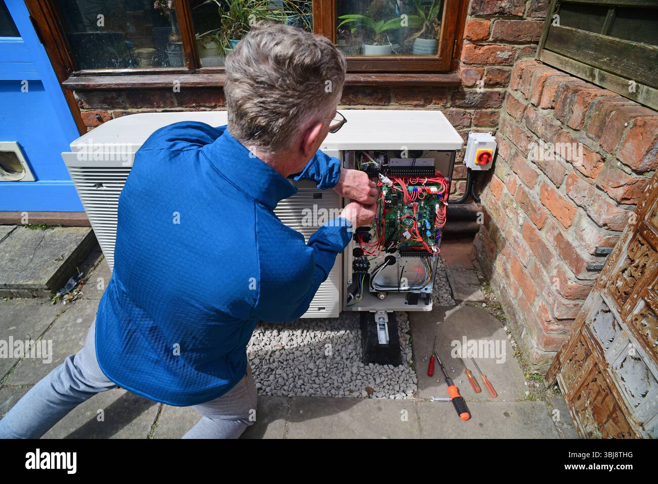 ingénieur installant la pompe à chaleur de source d'air royaume-uni Banque D'Images