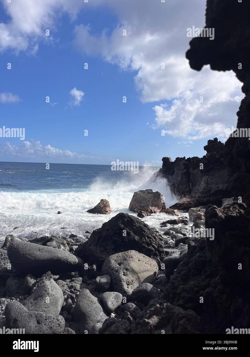 Les belles et magiques plages de sable noir sur la grande île de Hawai'i, États-Unis avec des roches de lave noire volcanique et des vagues qui s'écrasent. Banque D'Images