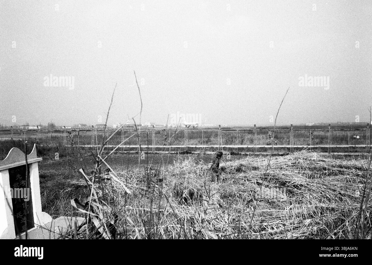 Fin des années 2000 Chine Jiangsu Yancheng International Airport Old Farmer ancestral grave terres agricoles d'hiver – modernité rurale contraste Banque D'Images