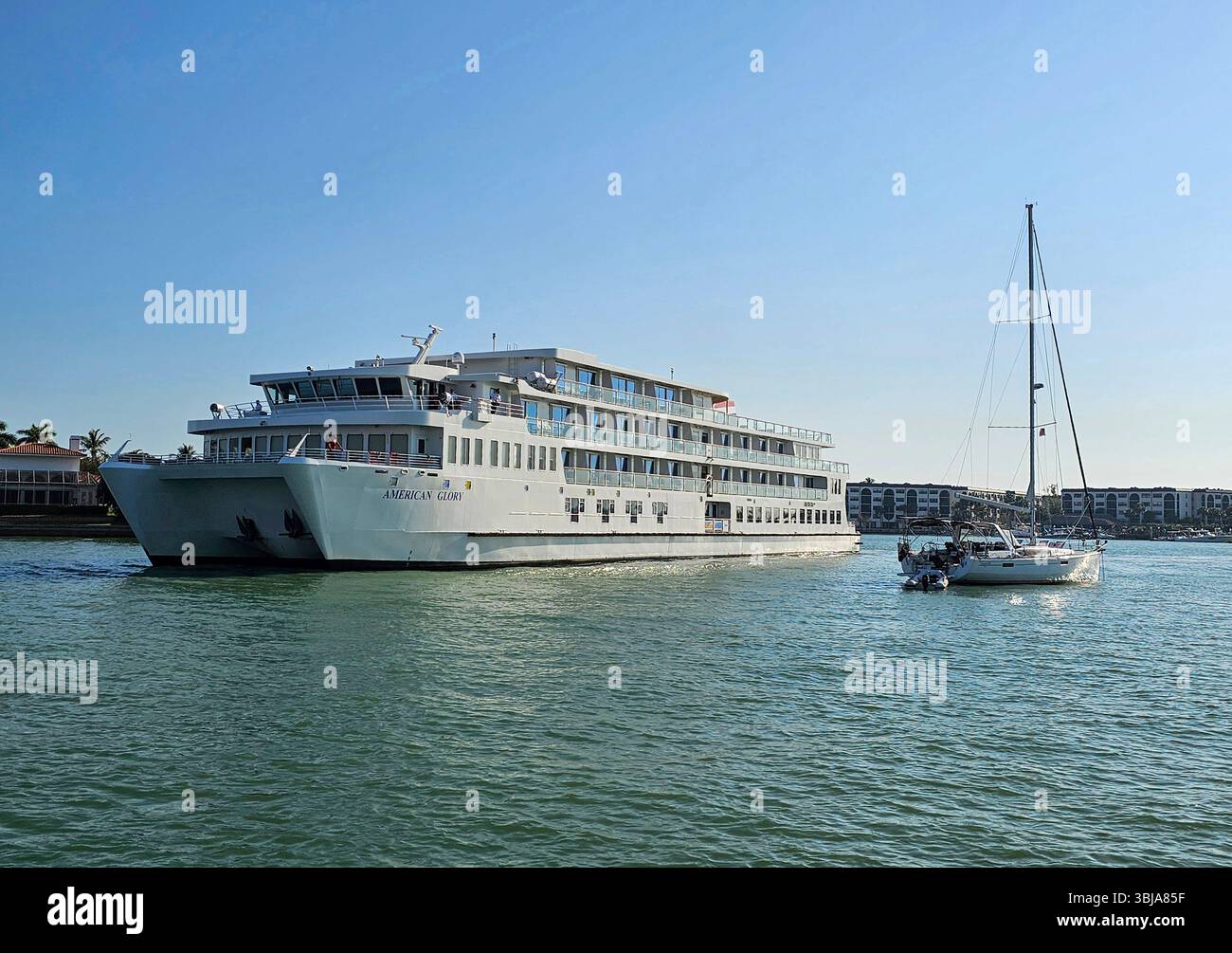 American Glory passe devant un voilier ancré au départ de Marco Island, en Floride Banque D'Images