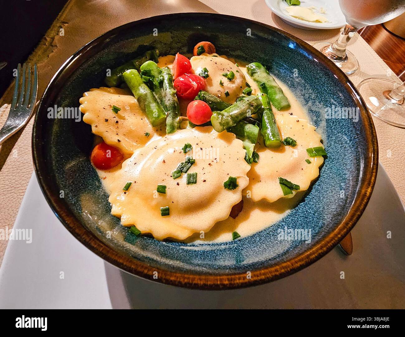 raviolis de homard aux asperges et tomates cerises servis avec une sauce au beurre blanc - Image de stock capturée avec un smartphone