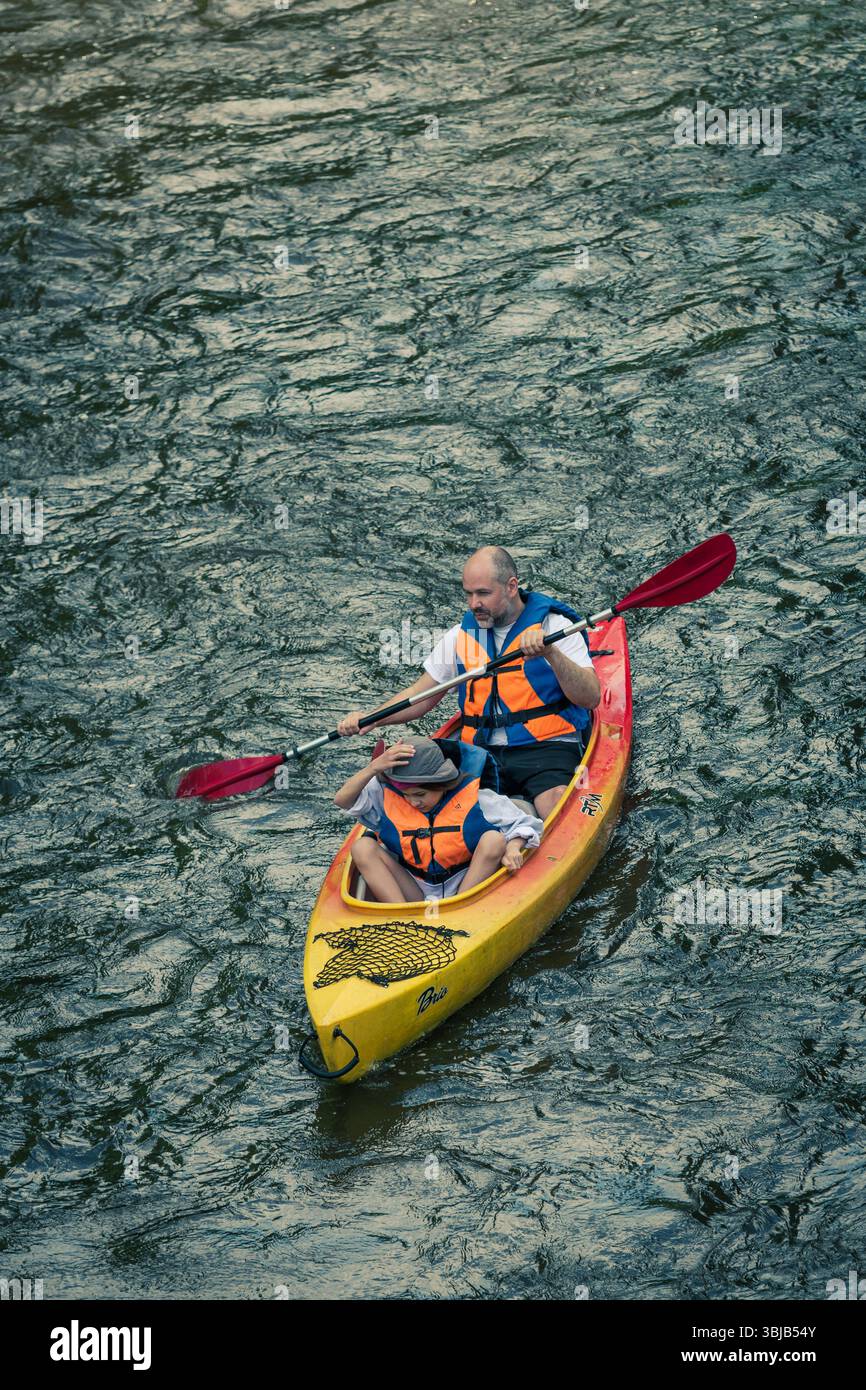 Père et petit enfant canoë ou kayak ensemble dans la rivière, verticale Banque D'Images