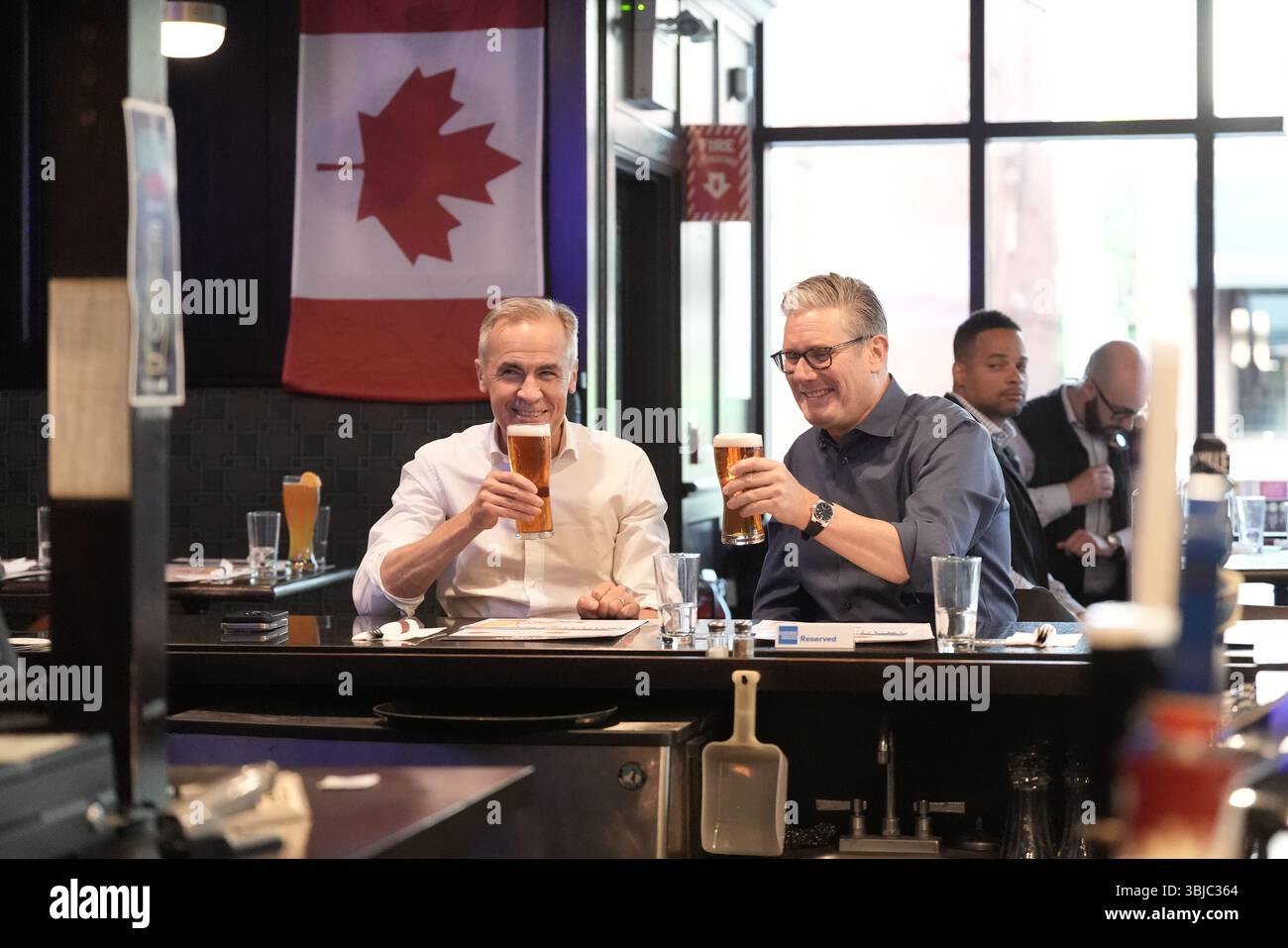 Le premier ministre Sir Keir Starmer et le premier ministre du Canada Mark Carney buvant de la bière en regardant une partie de hockey sur glace à la télévision entre les Oilers d'Edmonton et les Panthers de la Floride au pub Royal Oak à Ottawa, Canada, avant le sommet des dirigeants du G7. Date de la photo : samedi 14 juin 2025. Banque D'Images