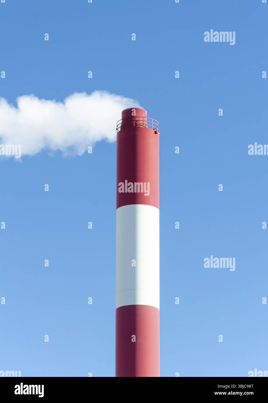 Plus de fumée cheminée industrielle avec ciel bleu Banque D'Images