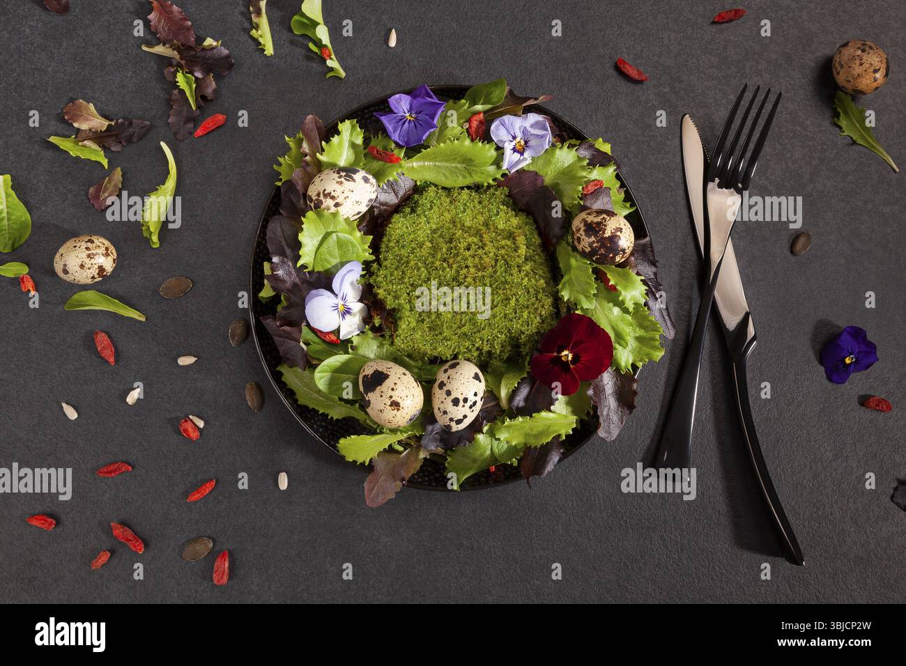 Couronne faite de feuilles de salade, de fleurs et d'œufs de caille d'en haut. Composition printanière avec une délicieuse salade pour illustrer une alimentation saine et diététique Banque D'Images