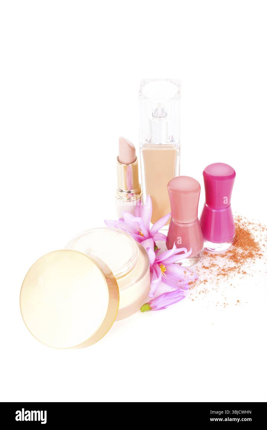 Fond cosmétique en beige et rose. Lotion anti-âge, rouge à lèvres beige, fond de teint, vernis à ongles, poudre pour le visage et fleur rose isolé sur dos blanc Banque D'Images