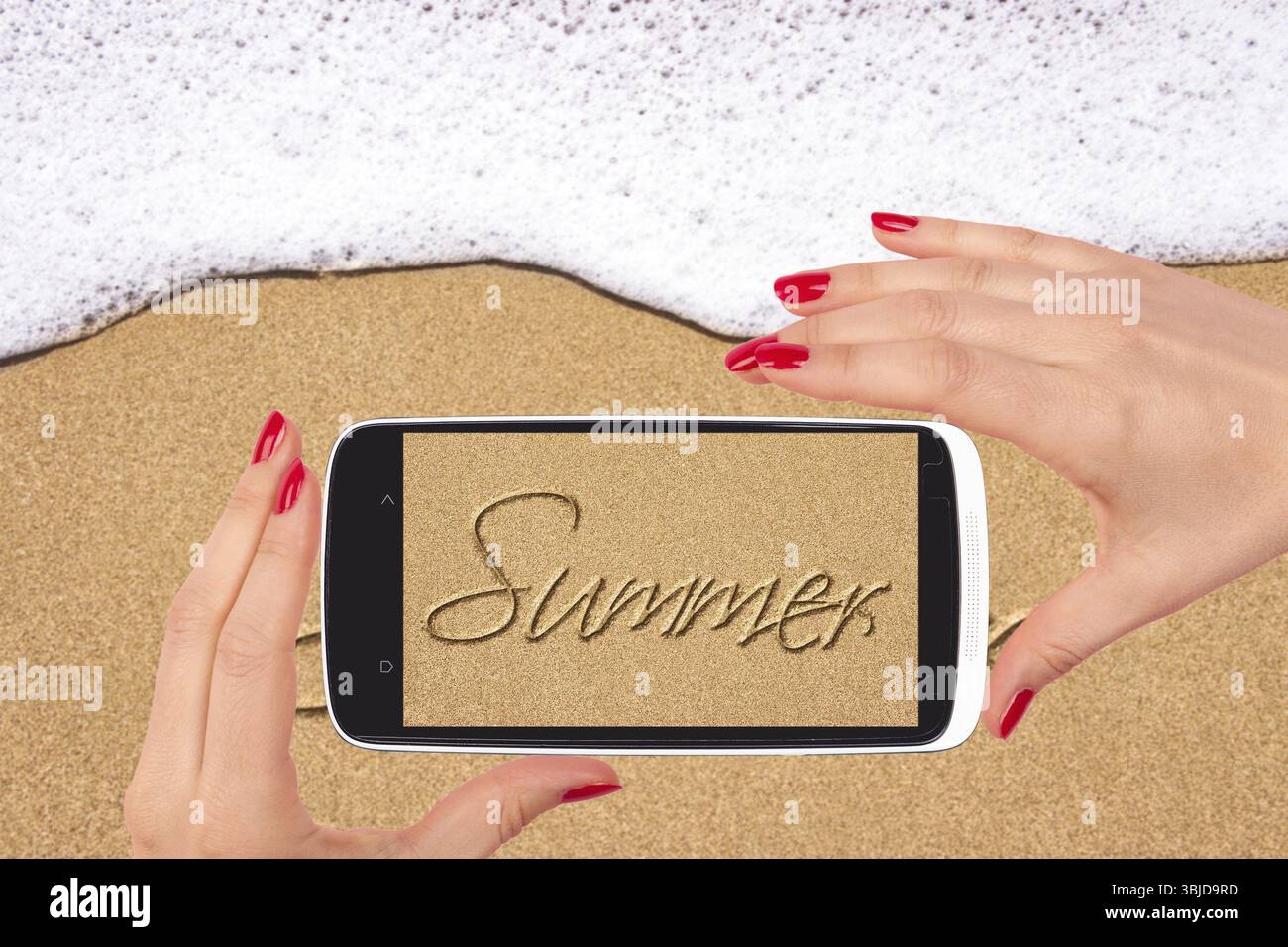 Instantané de plage. Plage de sable avec l'été écrit dans le sable sur l'écran de smartphone dans la main féminine. Femmes voyageant Banque D'Images
