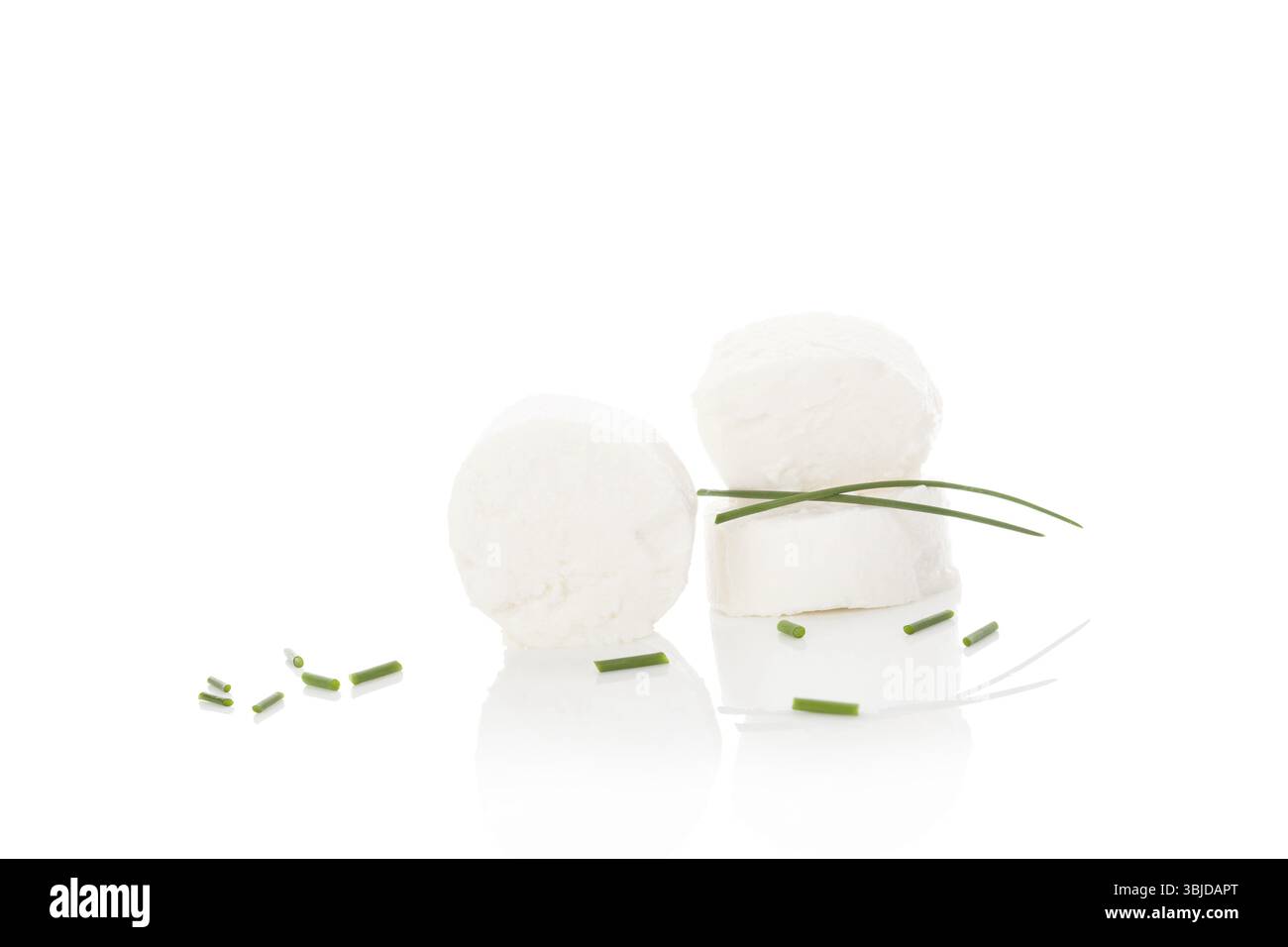 Fromage de chèvre avec ciboulette tranchée, isolé sur fond blanc. Manger du fromage de chèvre culinaire Banque D'Images