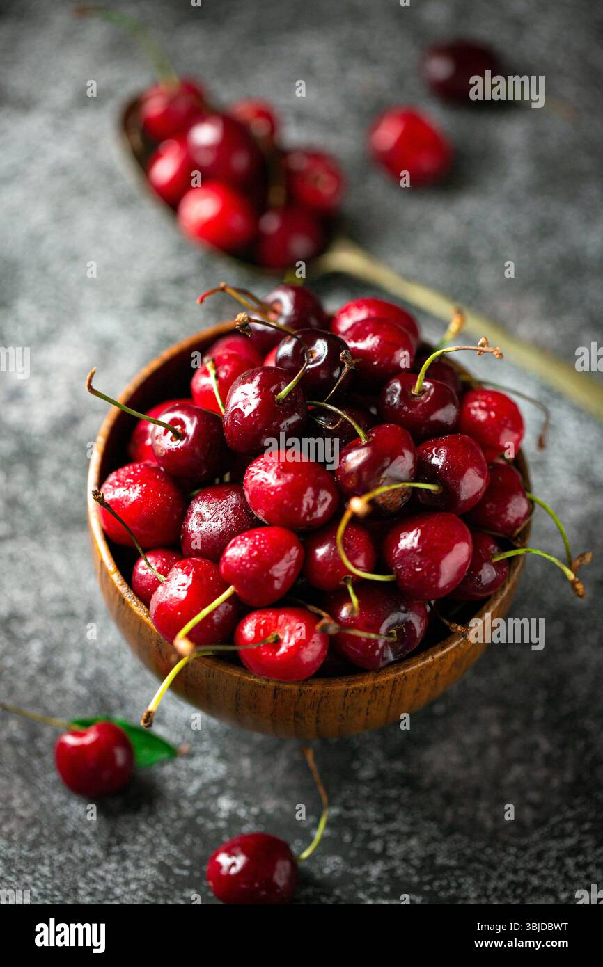 Assiette complète de cerises, cerises noires et rouges. Banque D'Images