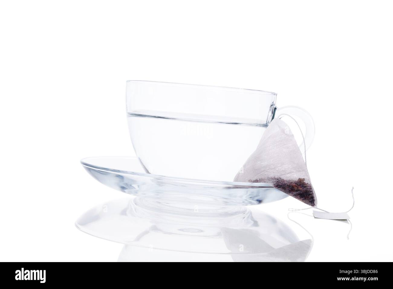 Tasse en verre transparent avec de l'eau chaude avec sachet de thé isolé sur fond blanc avec réflexion. Concept Tea Time Banque D'Images
