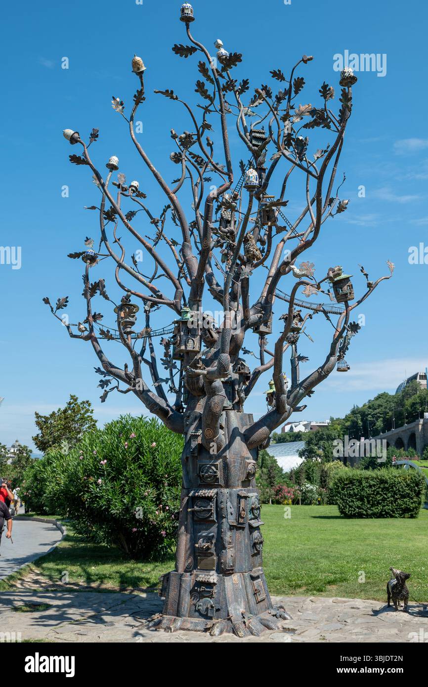 Sculpture artistique d'arbre en métal dans un cadre de jardin extérieur luxuriant à Tbilissi, Géorgie Banque D'Images