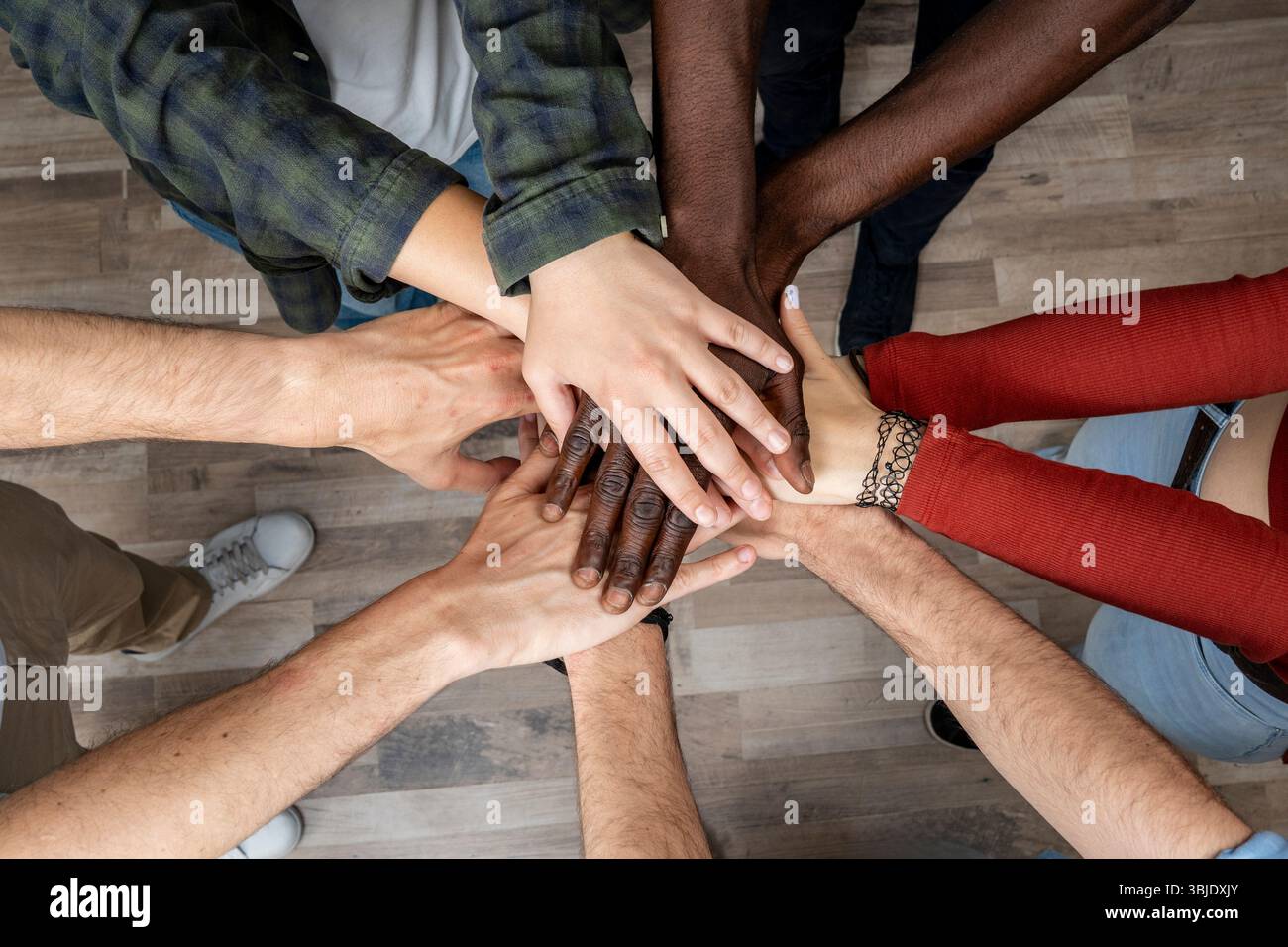 Groupe diversifié de personnes joignant les mains en cercle, symbole d'unité, de confiance, de travail d'équipe et d'amitié. Banque D'Images
