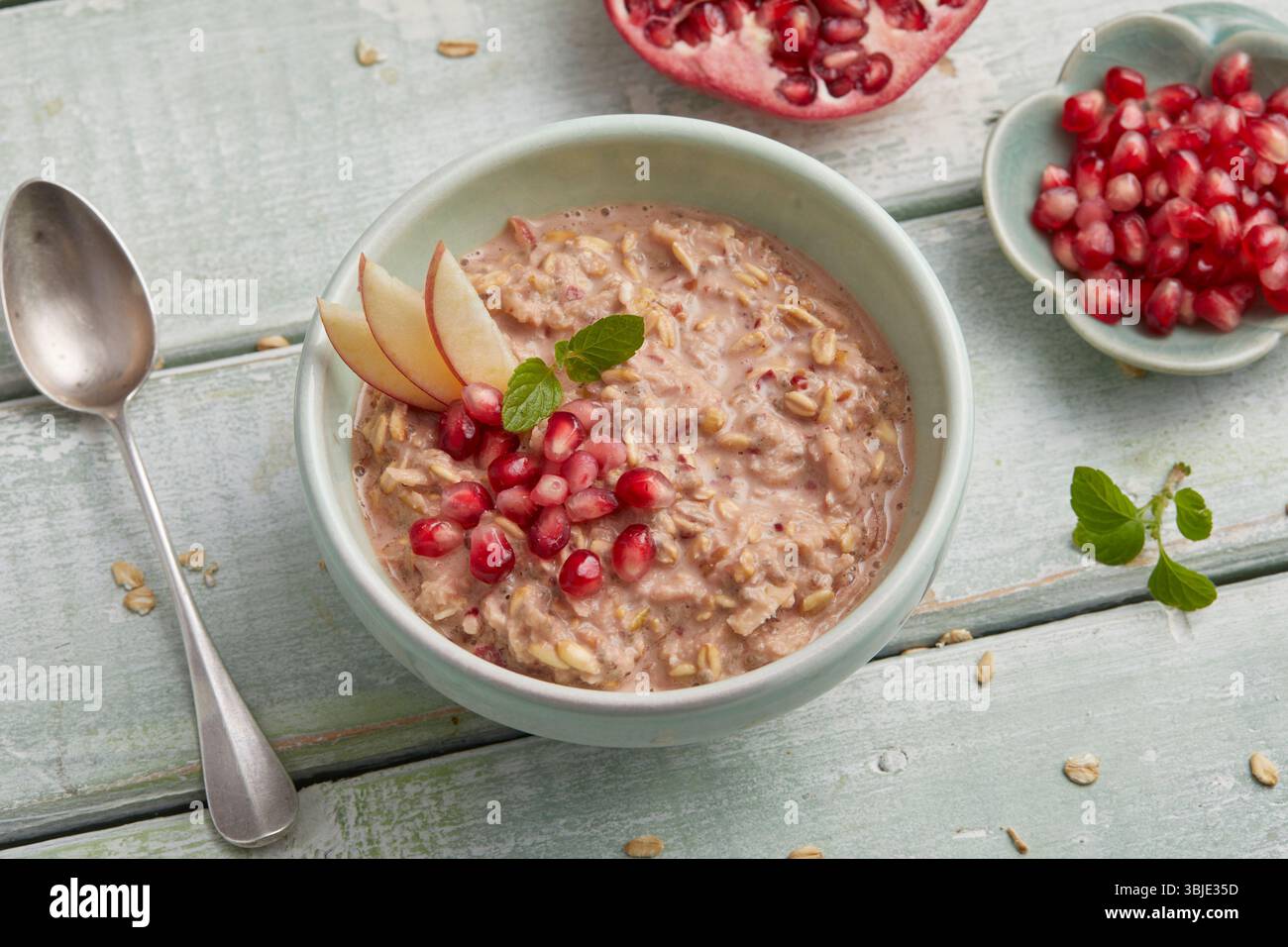 Avoine de nuit avec pomme et grenade – un petit déjeuner sain et coloré dans un bol, parfait pour la préparation des repas et le petit déjeuner. Banque D'Images