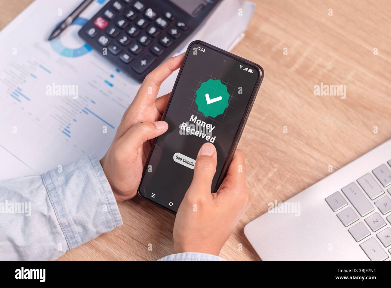 Main de femme tenant un smartphone avec l'écran du téléphone montrant un message d'argent reçu. Transactions bancaires en ligne ou de paiement sans espèces. Banque D'Images