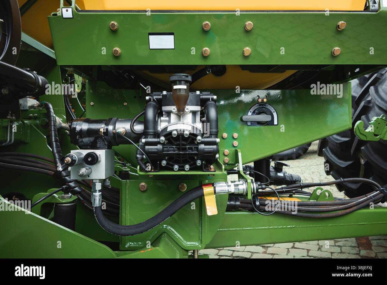 Matériel agricole avec composants hydrauliques et mécaniques visibles, y compris une pompe centrifuge, des raccords hydrauliques, des flexibles et une commande Banque D'Images