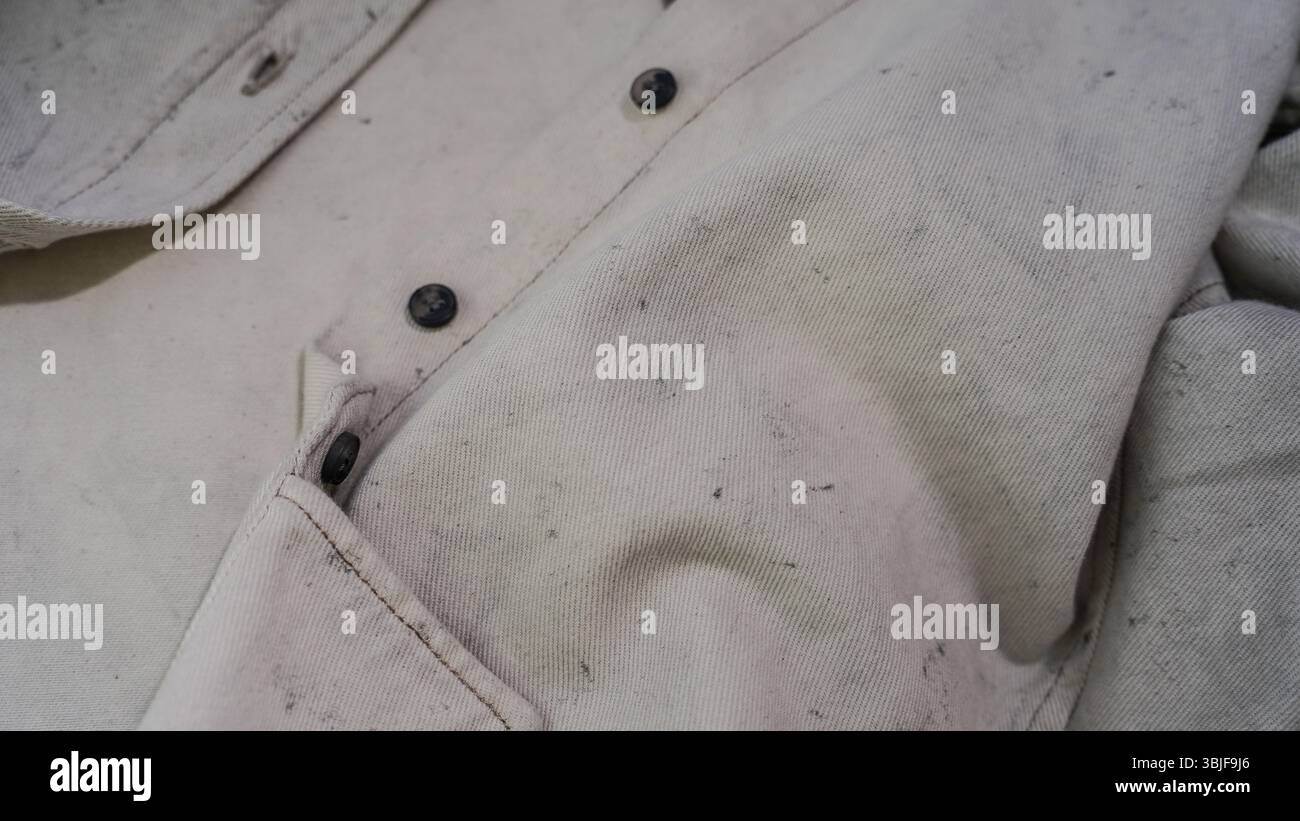 Gros plan de chemise textile beige clair avec motif moucheté et détails de bouton Banque D'Images