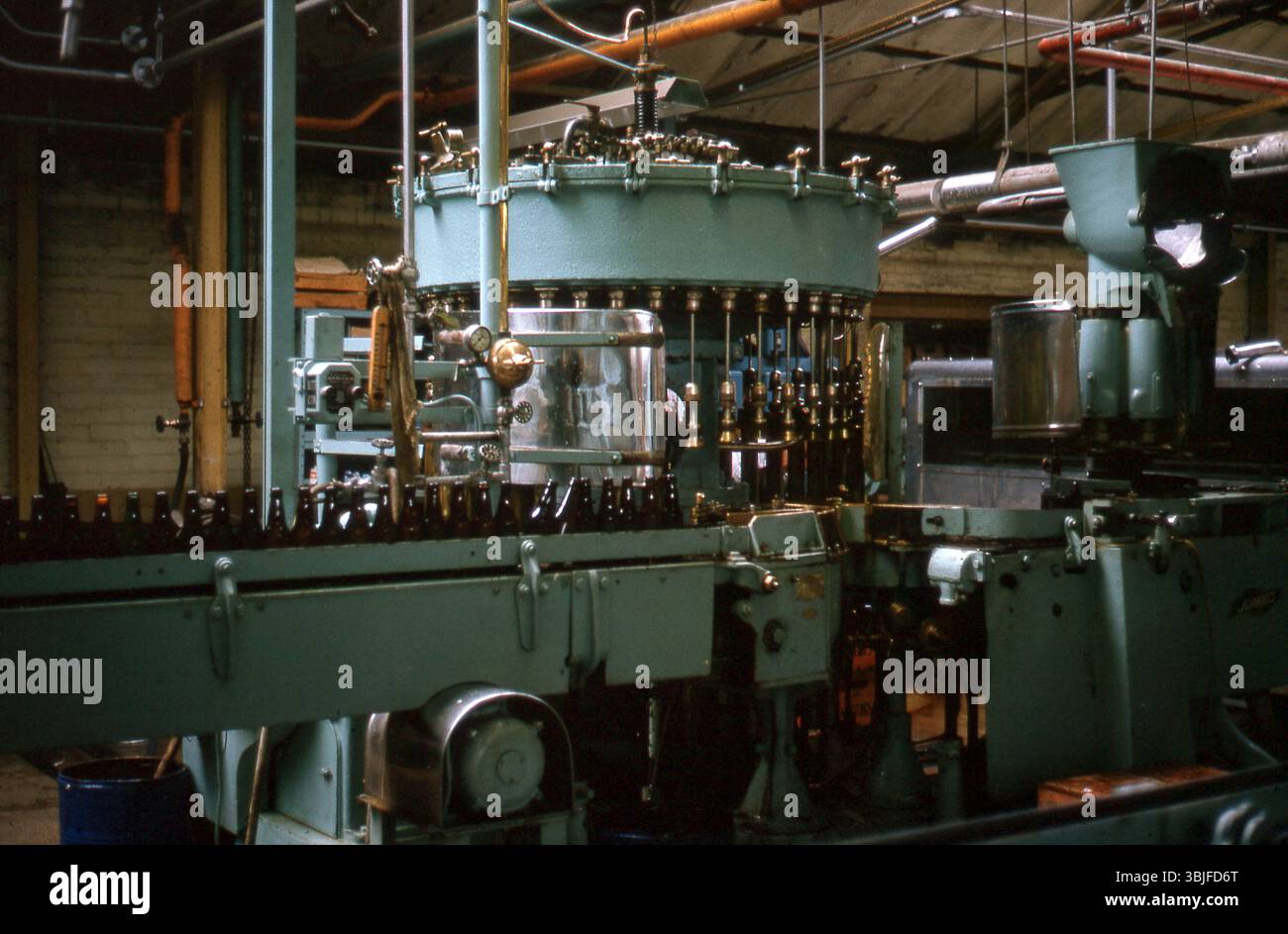 Angleterre dans les années 1960 - Une machine d'embouteillage de bière en opération dans une brasserie, en 1964 Banque D'Images