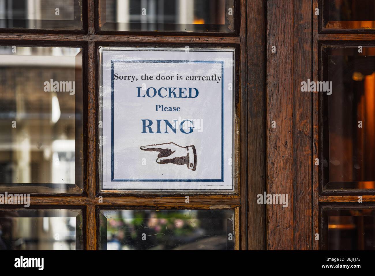 Porte de magasin en bois verrouillée avec panneau de papier de sonner et avis de direction de flèche Banque D'Images