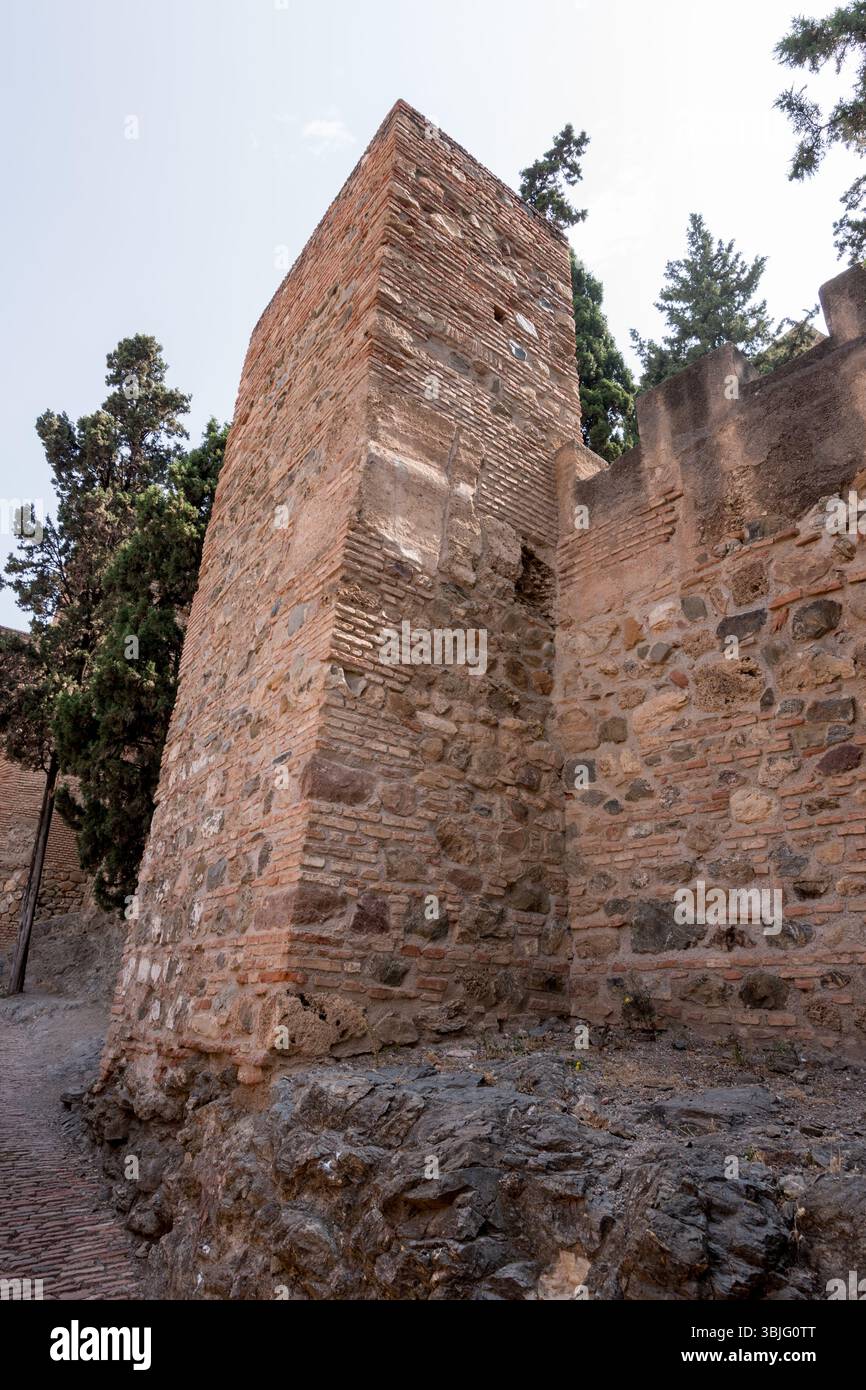 Tour d'angle de l'Alcazaba de Málaga, construite avec des couches de brique et de pierre, debout haut comme un rappel de la force défensive mauresque. Banque D'Images