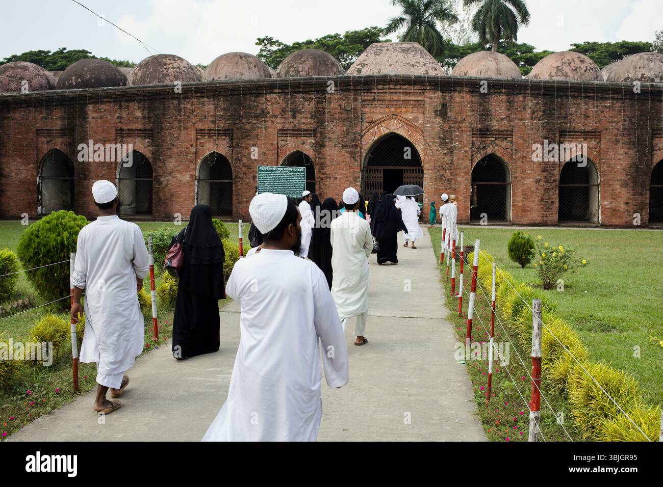 Les fidèles marchent vers la Mosquée historique Sixty Dome à Bagerhat, au Bangladesh, un site classé au XVe siècle au patrimoine mondial de l'UNESCO. Banque D'Images