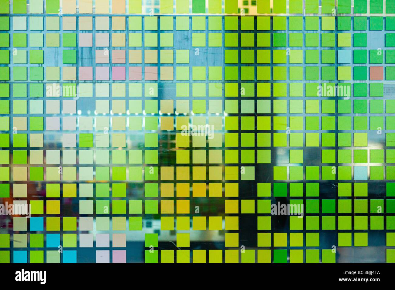 Mosaïque de petits carrés vert-jaune sur verre, gros plan. Carrés numériques de style matriciel. Banque D'Images