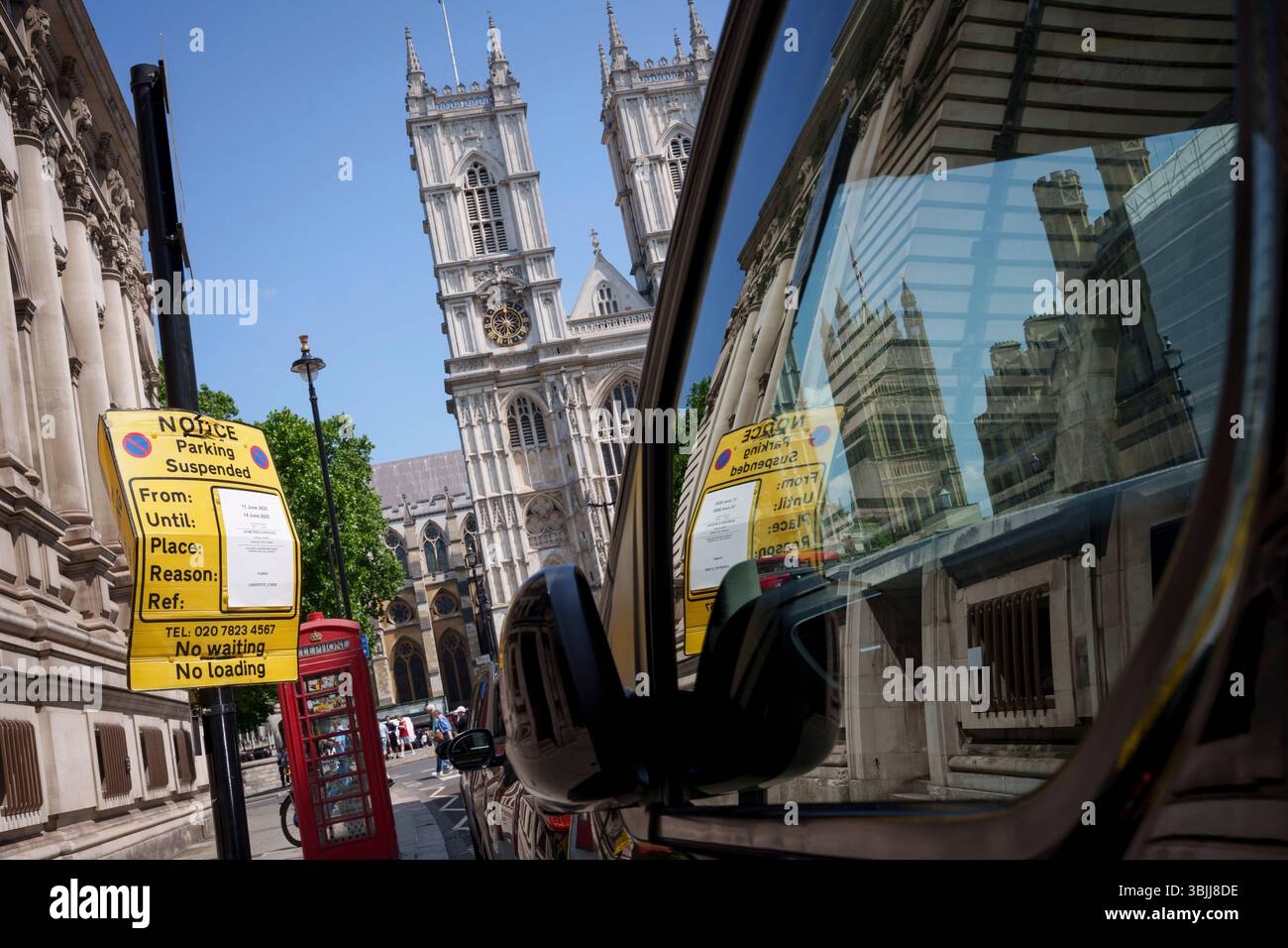 Un panneau d'avertissement de restriction de stationnement est reflété dans un véhicule garé devant l'abbaye de Westminster un jour avant la cérémonie annuelle du Trooping of the Colour, le 13 juin 2025, à Londres, en Angleterre. Banque D'Images
