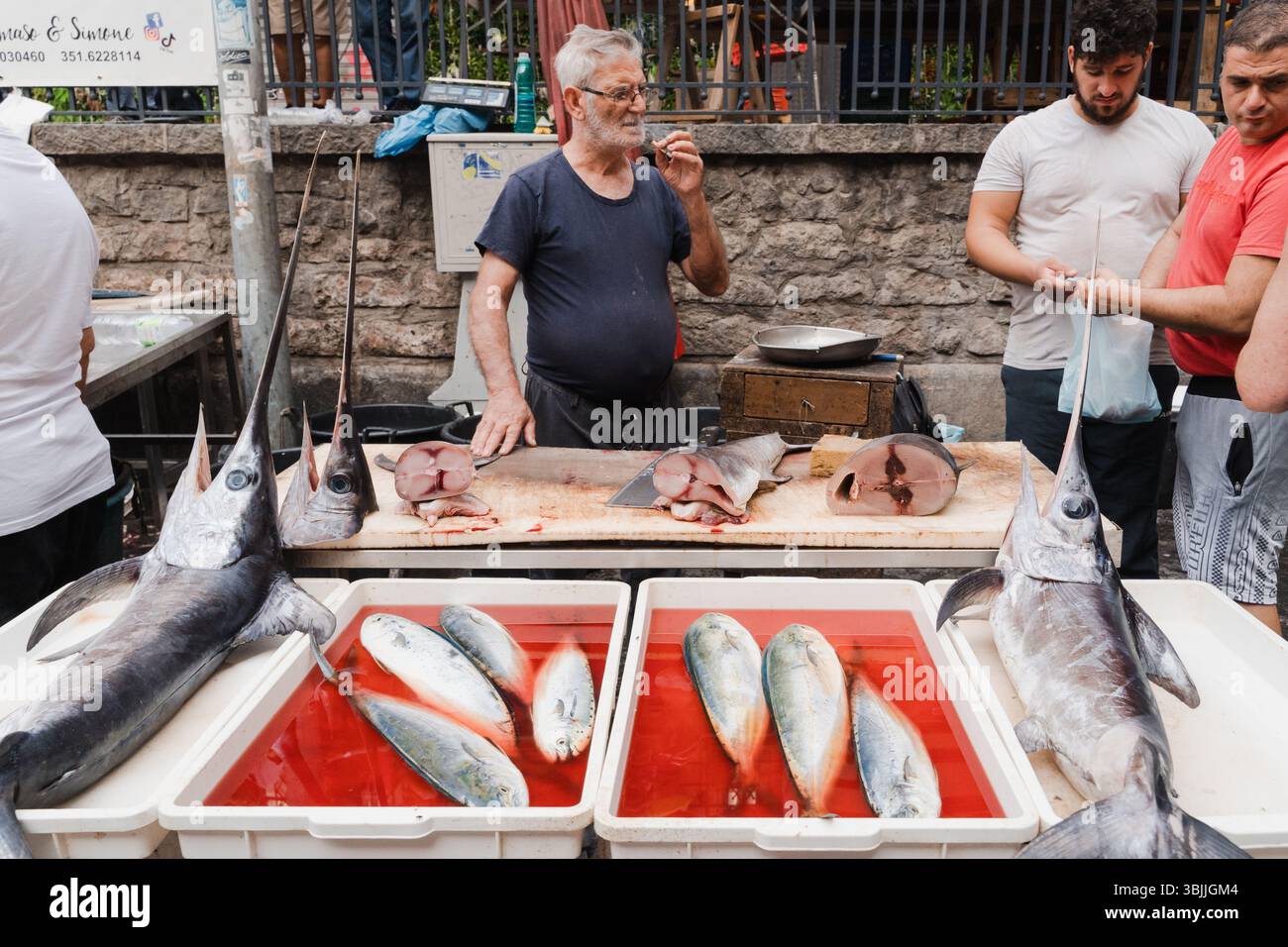 Un vendeur d'espadon frais sur un marché aux poissons en Sicile Banque D'Images
