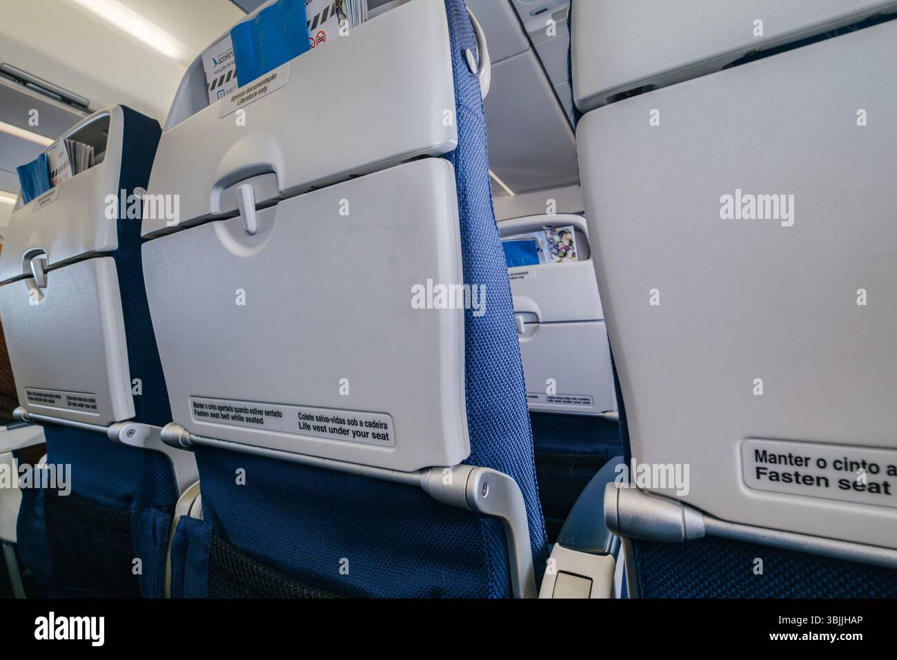 Sièges de cabine d'avion vides du point de vue passager, prêts pour le vol. Aviation commerciale, intérieur de voyage aérien, Design bleu et gris, Aircra moderne Banque D'Images