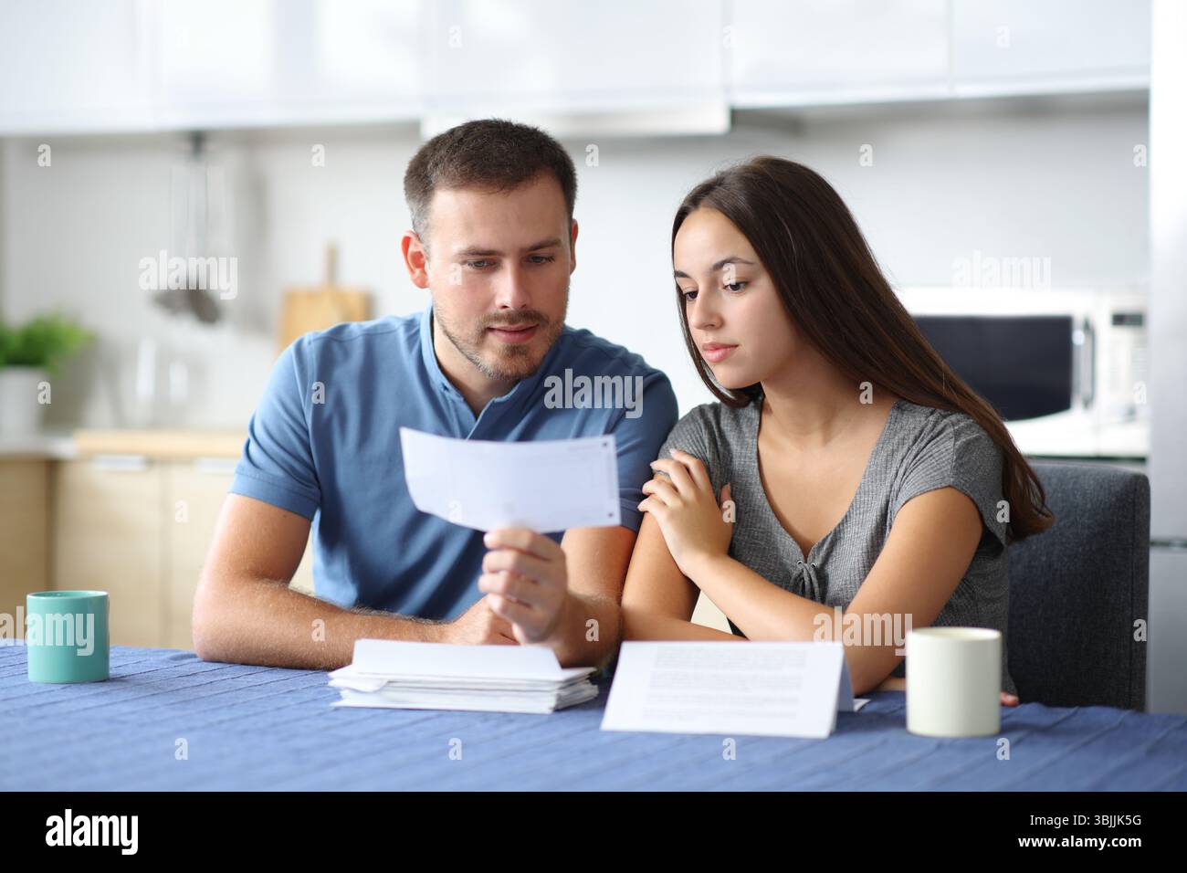 Seriour couple vérifiant le relevé bancaire dans la cuisine à la maison Banque D'Images