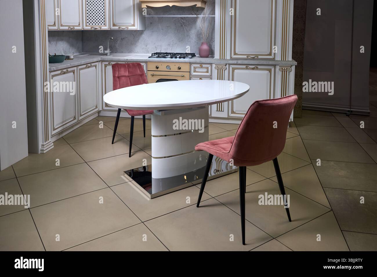 Intérieur de la cuisine moderne dans un style classique avec des éléments dorés dans des couleurs beiges avec des appareils intégrés plaque de cuisson à gaz évier en pierre de four électrique et extrait Banque D'Images