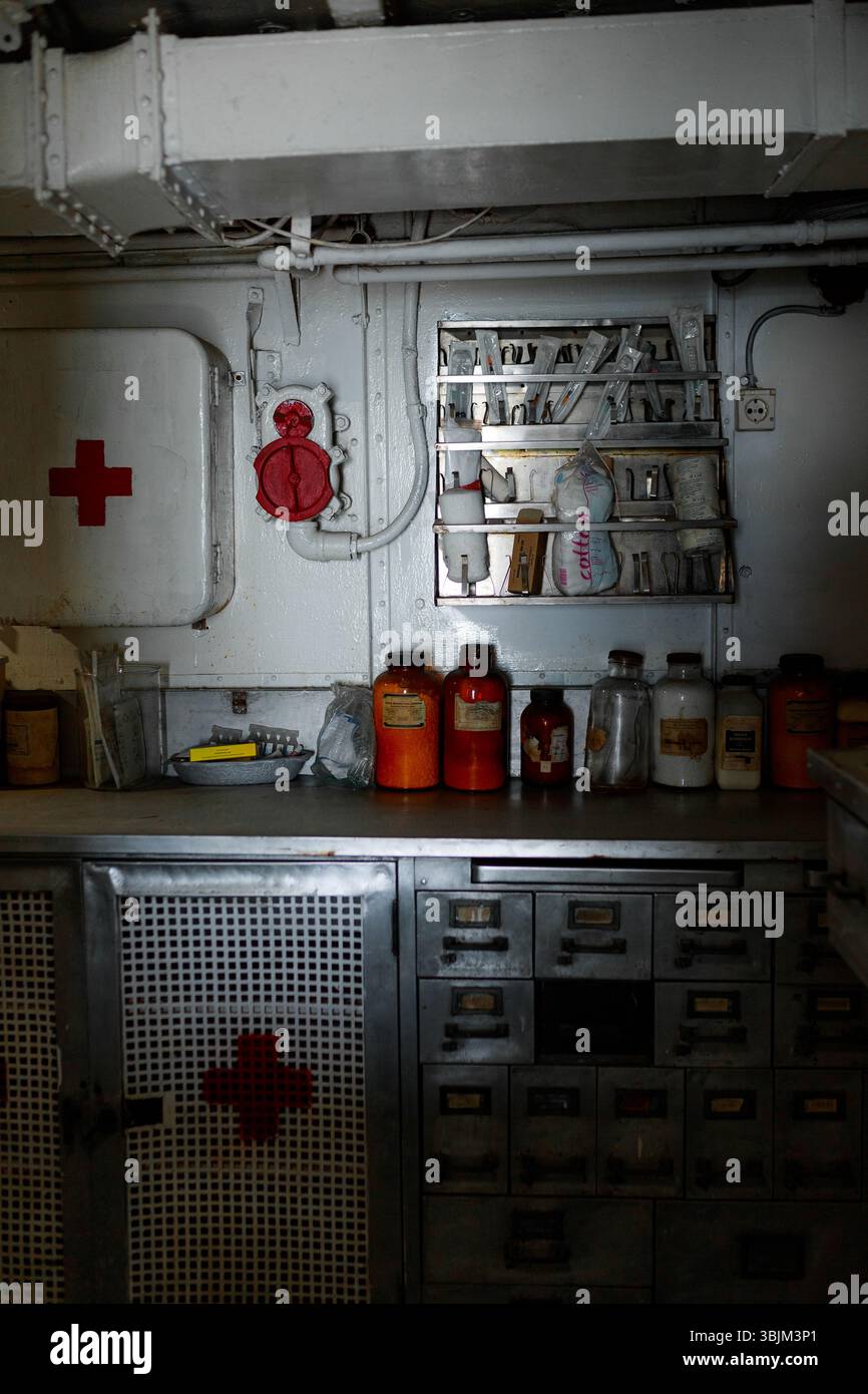 Ancienne armoire médicale avec des bocaux, des fioles et des outils dans la salle de premiers soins en métal du navire. Banque D'Images