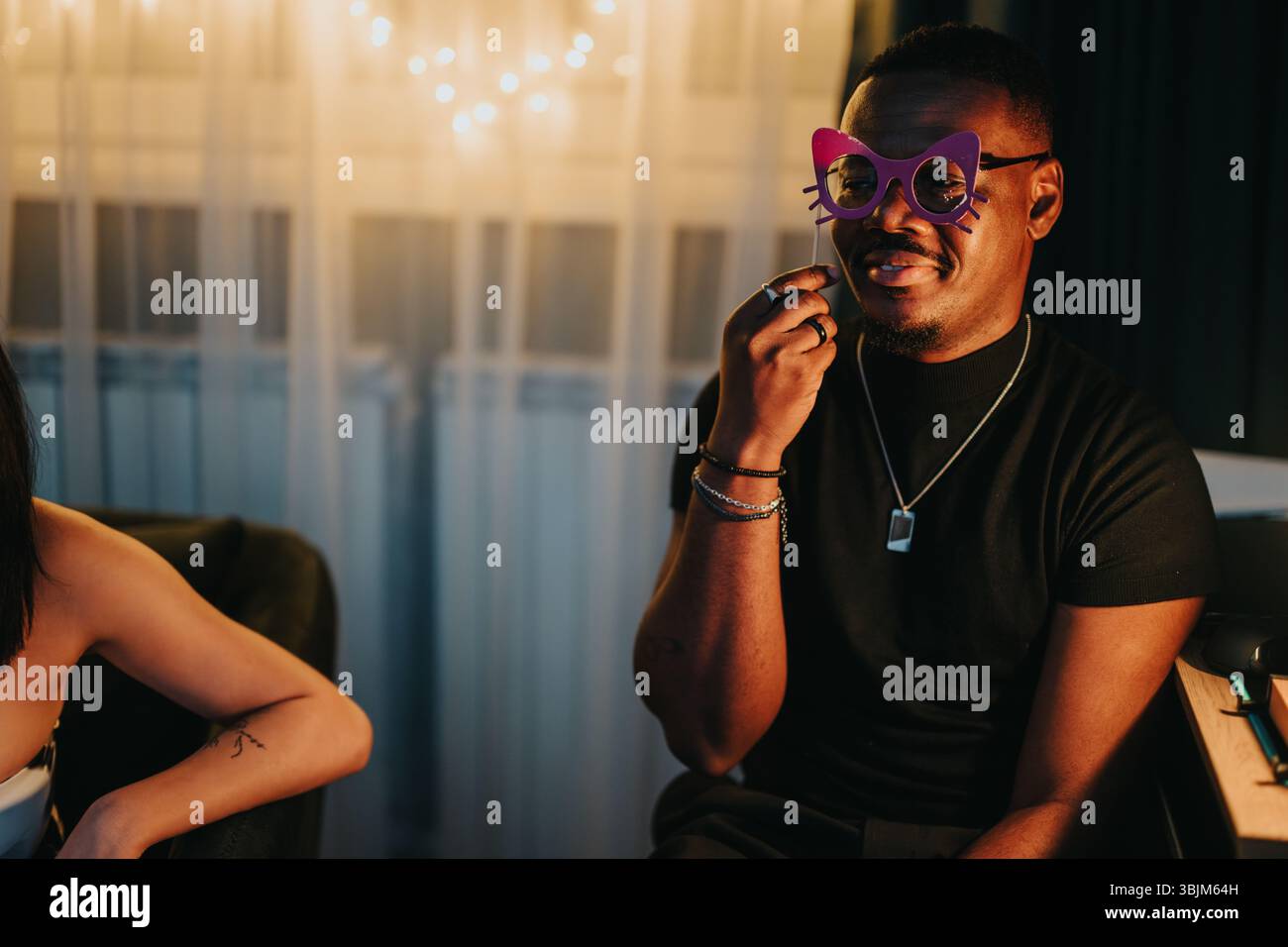 Homme portant des lunettes Cat-Eyes amusantes pendant la fête en intérieur Banque D'Images