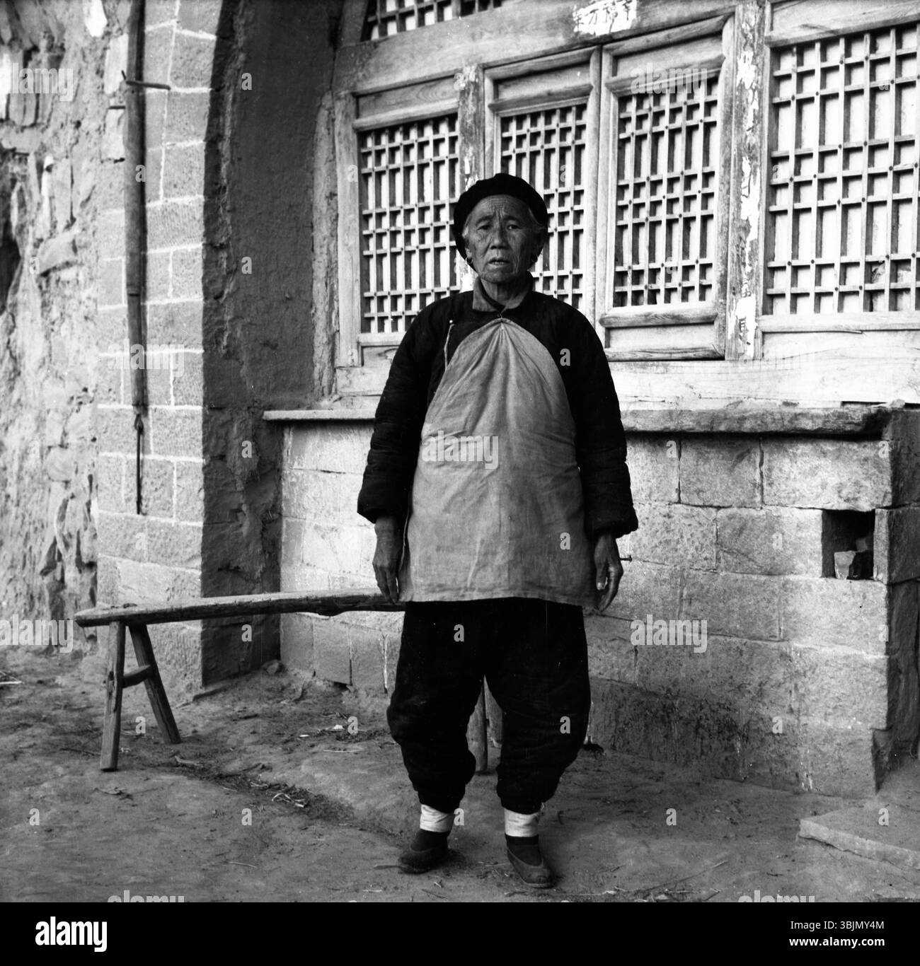 Années 1970 Chine Portrait de femme âgée rurale - toile de fond de l'habitation de la grotte du plateau de Loess Banque D'Images