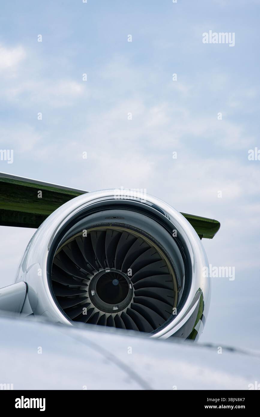 Moteur à réaction et queue en T d'un avion d'affaires Gulfstream de luxe sous un ciel partiellement nuageux. Fuselage poli et détails de turbine clairement visibles. Banque D'Images