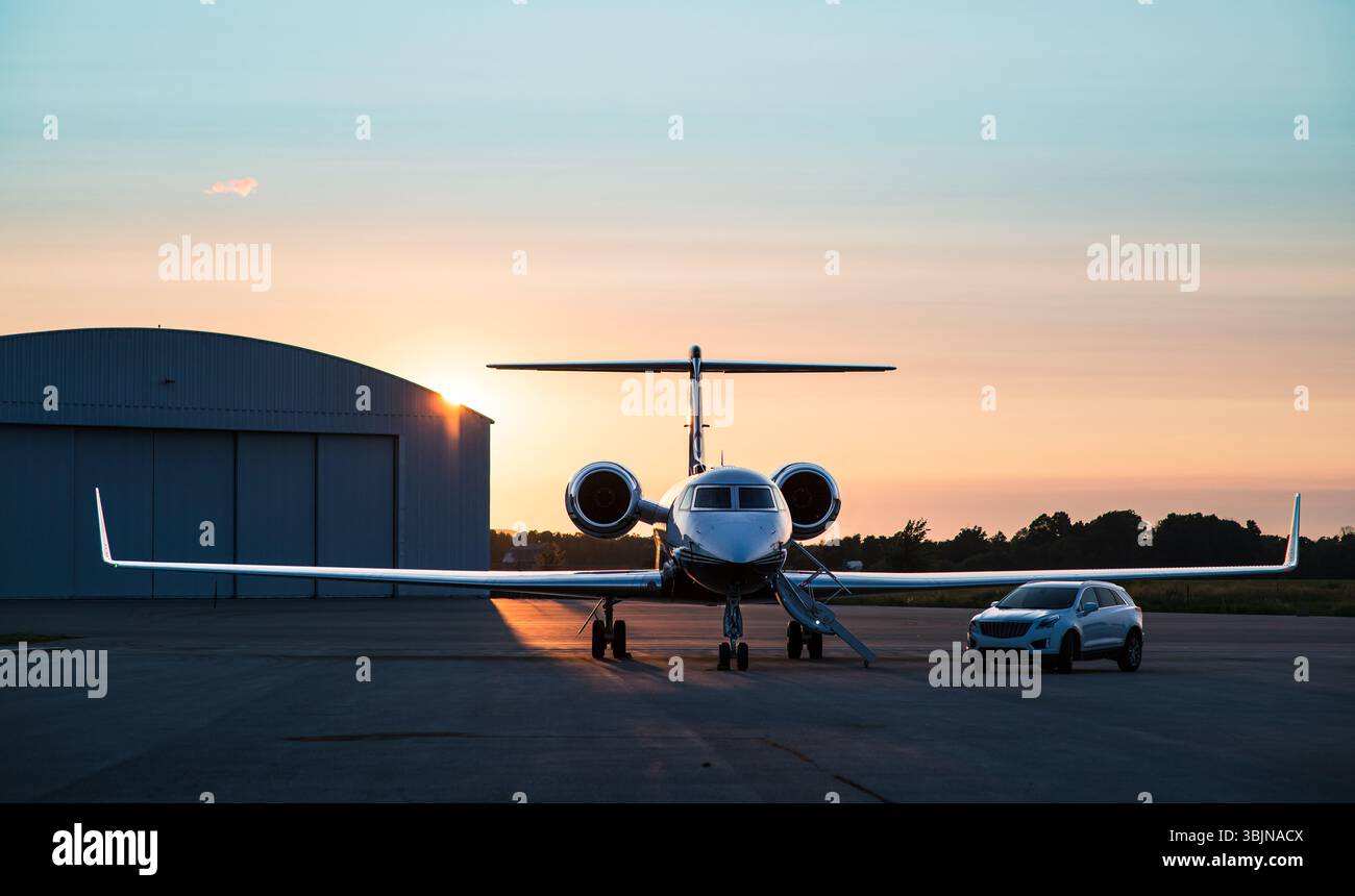 Jet privé de luxe et SUV sur le tarmac au coucher du soleil. Prêt pour le départ, incarnant le voyage exclusif et le transport haut de gamme. Banque D'Images
